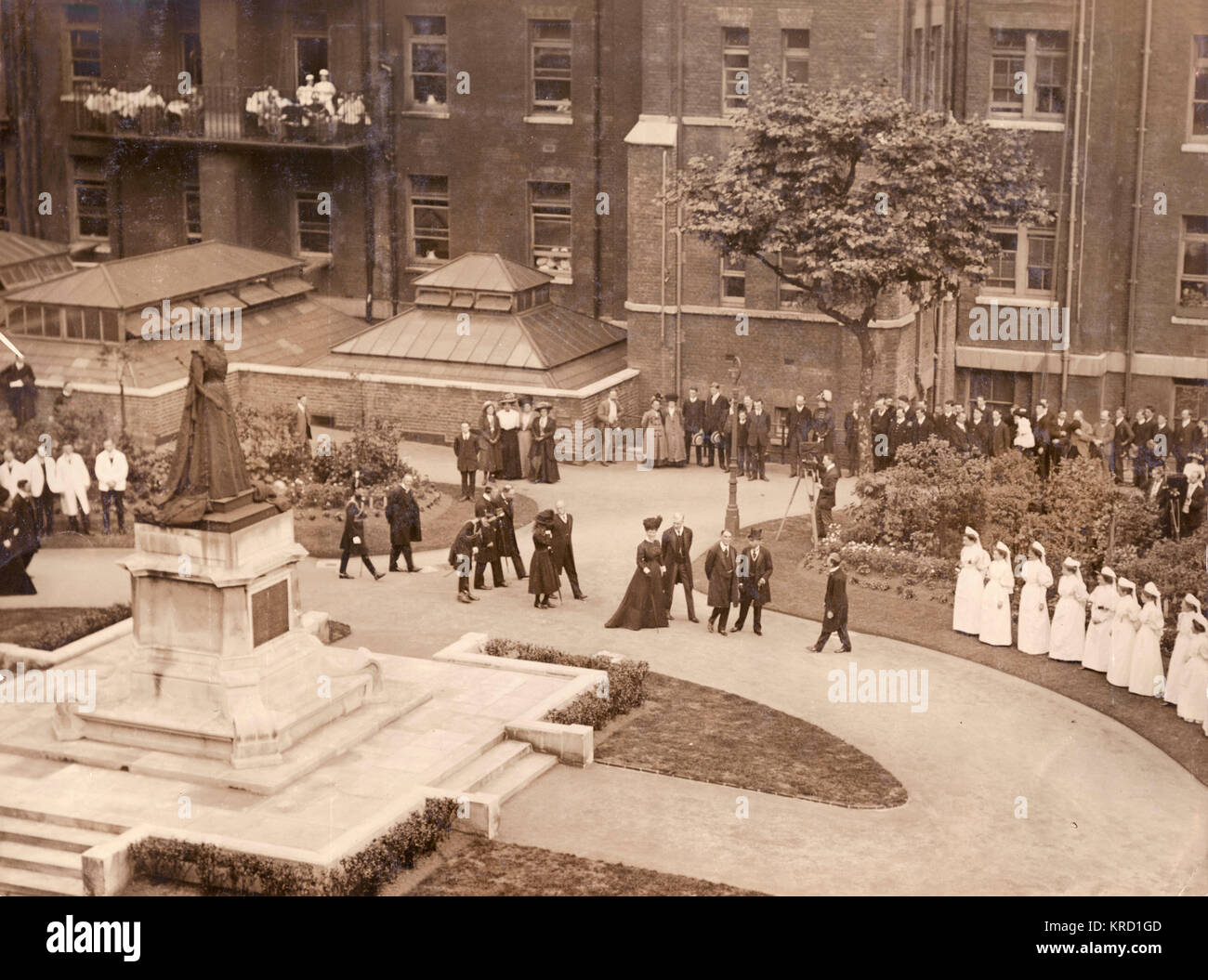 King George V and Queen Mary on a visit to the London Hospital in Whitechapel, East London.  The statue is of Queen Alexandra, George V's mother -- she became President of the hospital in 1904, and her statue was erected in 1908.          Date: circa 1910 Stock Photo