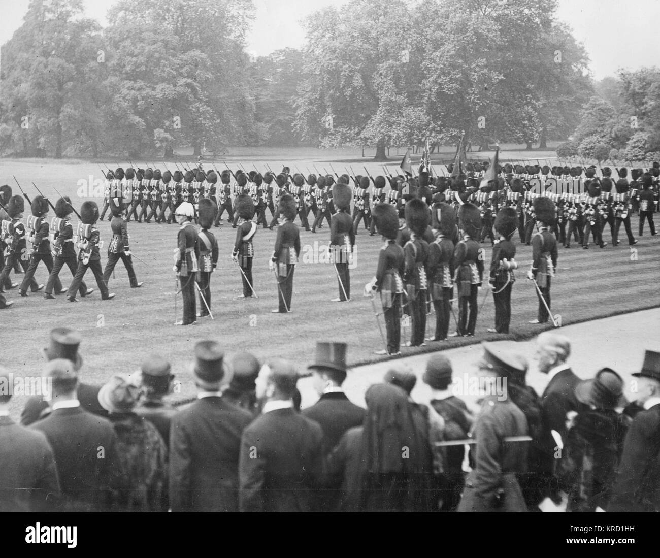 King George V presenting new colours to the Irish Guards at Buckingham Palace.  The King and the Prince of Wales watch the troops march past with the colours.       Date: circa 1912 Stock Photo