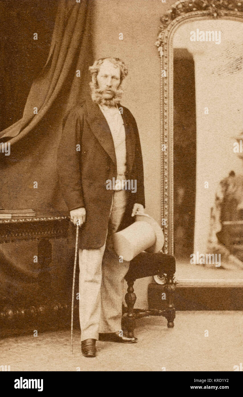 A Victorian man standing by a mirror.  It is probably Frederick Charles Polhill-Turner (1826-1881), around the time of his wedding to Emily Frances Barron in 1852.  He became a Justice of the Peace, Deputy Lieutenant, High Sheriff for Bedfordshire in 1855 and MP for Bedford 1874-1880.      Date: circa 1850s Stock Photo