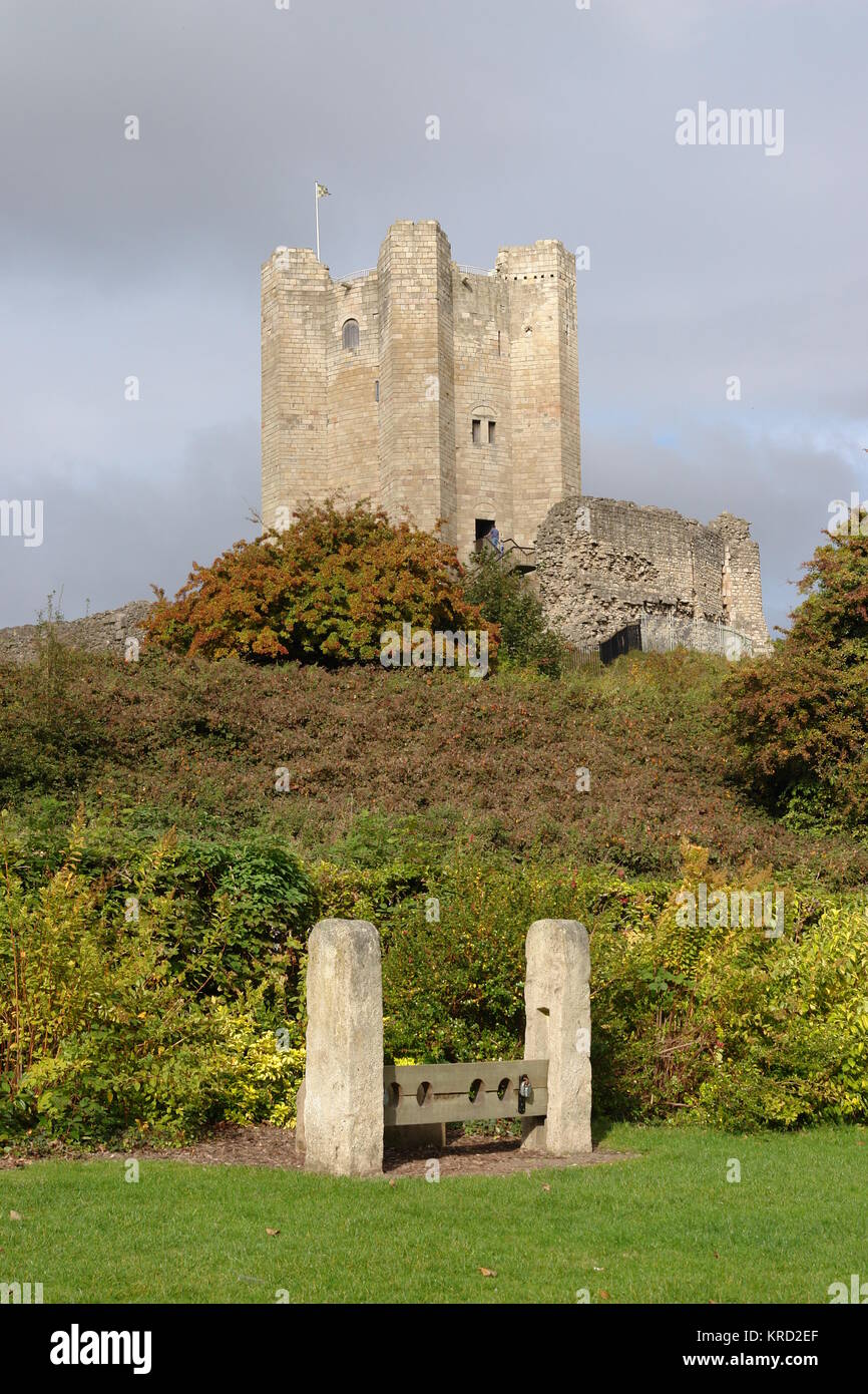 View of Conisbrough Castle, near Doncaster in South Yorkshire.  It was built in the 1180s by by the fifth Earl of Surrey, half brother of Henry II, and has the finest circular Norman keep tower in the UK.  A set of stocks can be seen in the foreground.      Date: October 2007 Stock Photo