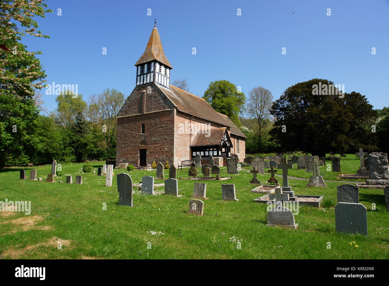 St Michael and All Angels Church, a Norman church in Castle Frome, Herefordshire, seen from across the churchyard.  The turret was added in the 19th century. Stock Photo