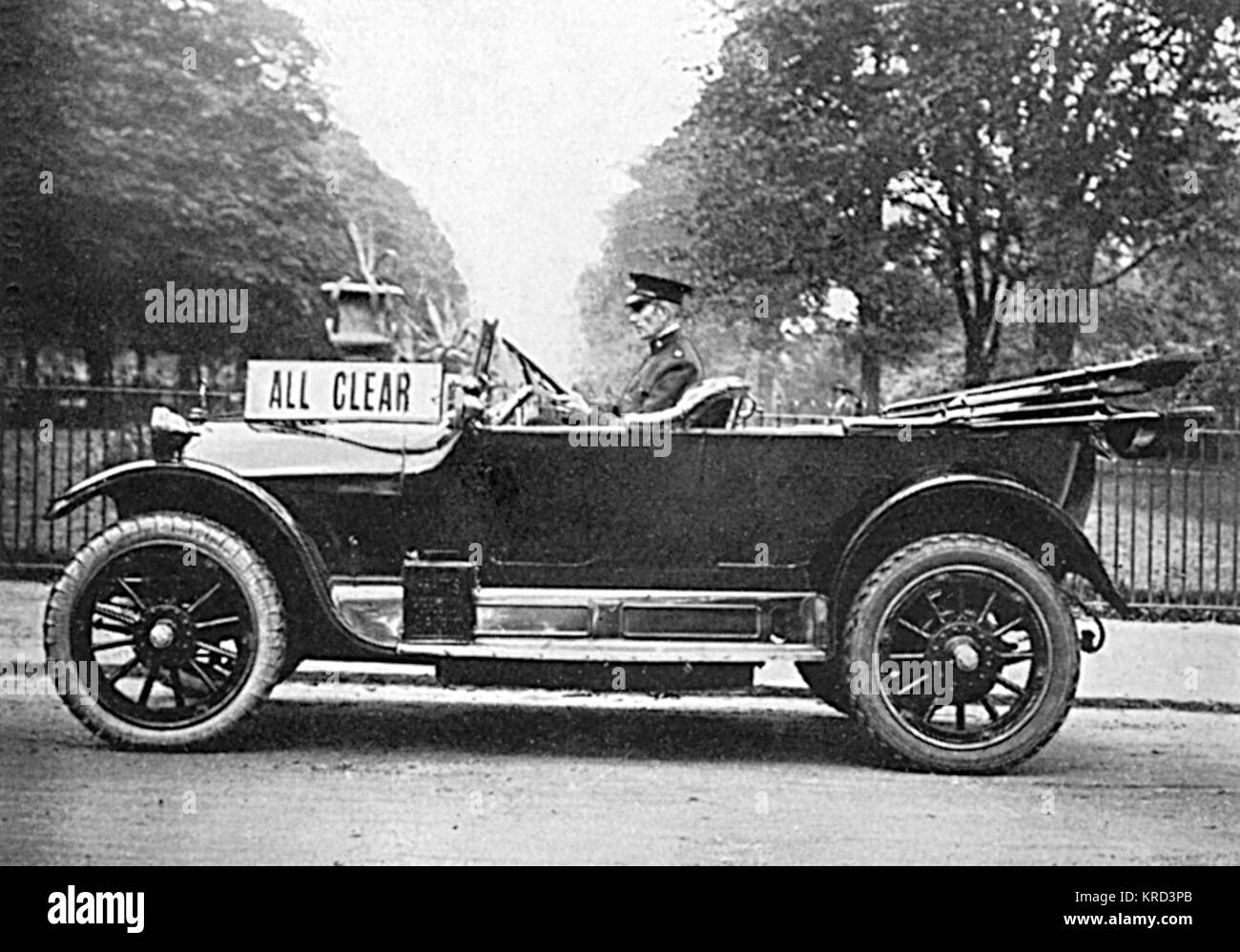 Side view of a motor car driven by a special constable with a sign informing the public of the all clear following an air raid.  Warning of air raids was only given from 1917 onwards and prior to that, the public were told to rely on 'darkness and composure' as a means to establishing whether a raid was in progress!     Date: 1914-1918 Stock Photo