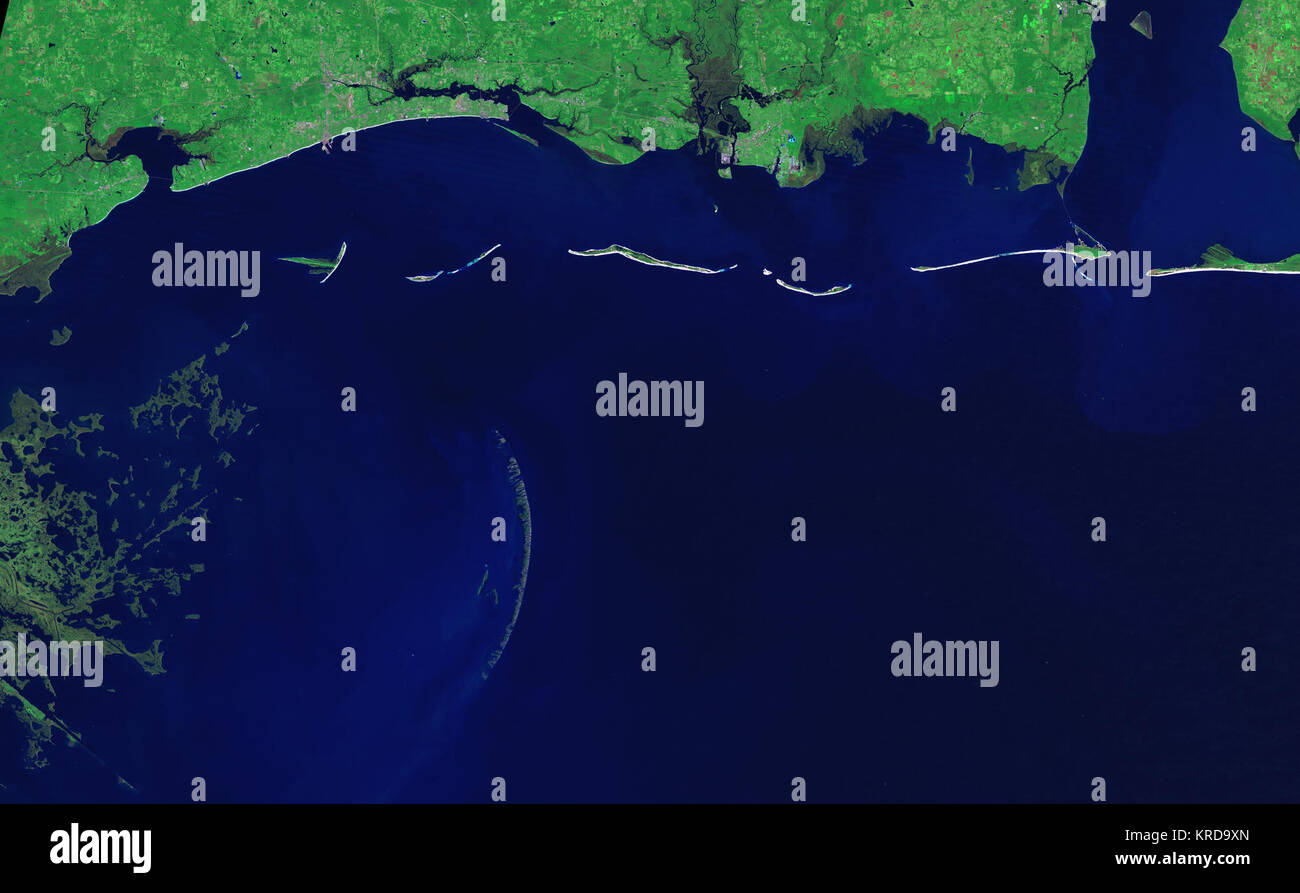 The graceful curve of the Chandeleur Islands resembles a multi-boned spine connecting the Mississippi Gulf coast to the delta of the Mississippi River in Louisiana. Like all barrier islands, the Chandeleur Islands form a thin protective wall between the open sea and the mainland, in this case Louisiana's St. Bernard Parish. The islands absorb the strongest waves, sheltering the mainland during large storms. It is no surprise, then, that barrier islands along the U.S. Gulf Coast changed dramatically in the wake of Hurricane Katrina, and no change is as dramatic as that seen in the Chandeleur Is Stock Photo