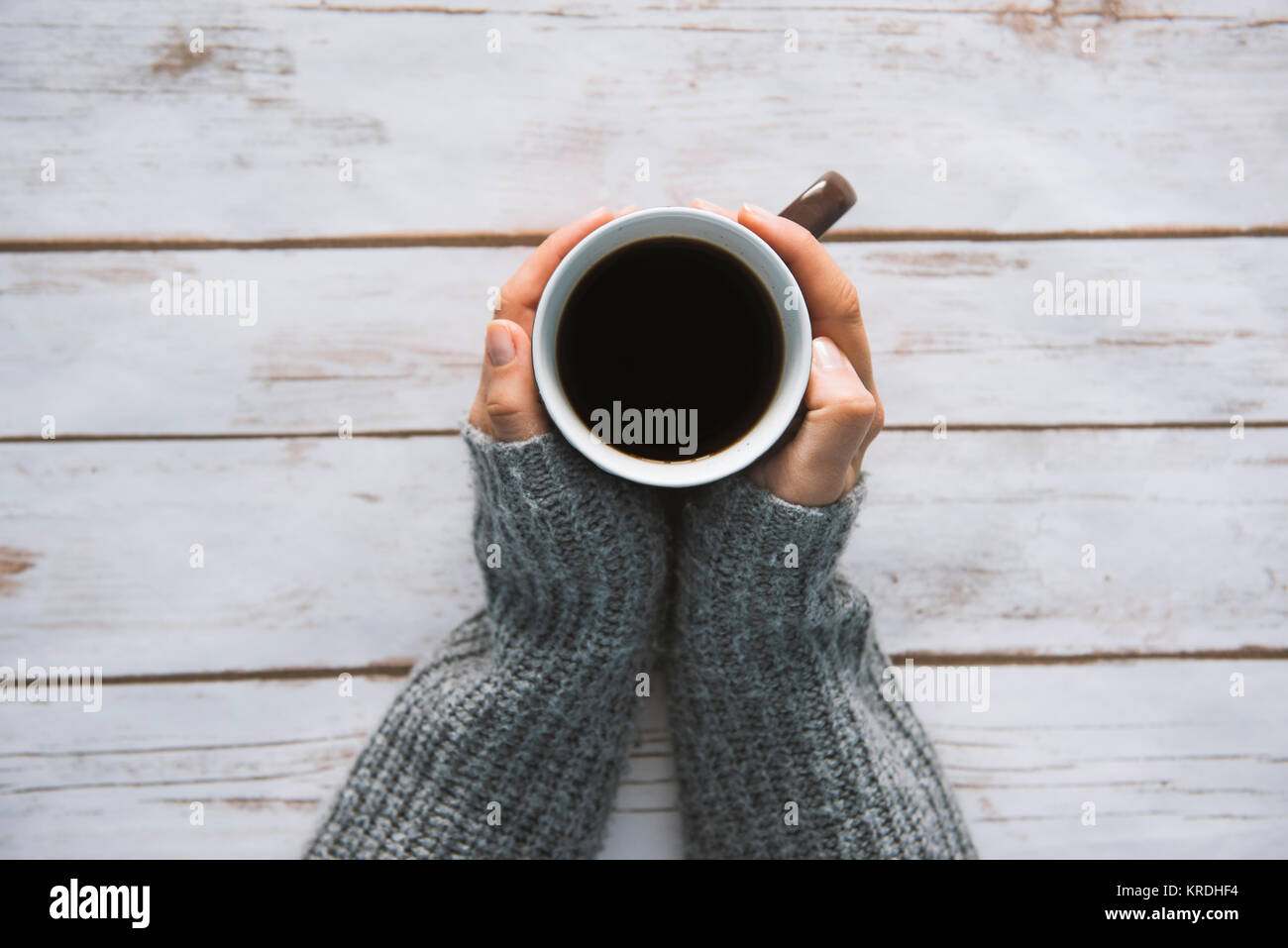 Girl holding a coffee cup on a wooden vintage background - winter time concept Stock Photo