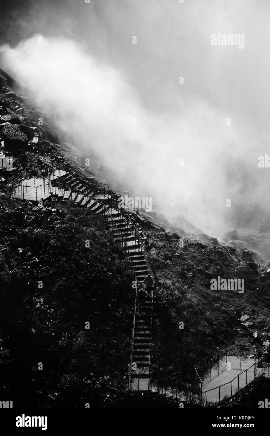 Monochrome photograph, tourists walk under American Falls at Niagara