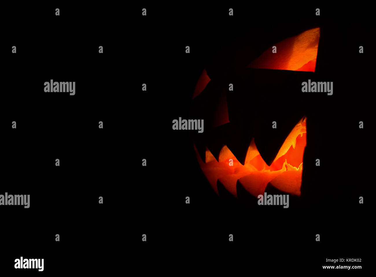carved face of pumpkin glowing on Halloween black background Stock ...