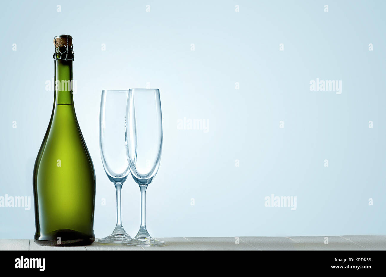 Glasses with champagne and bottle over sparkling holiday background