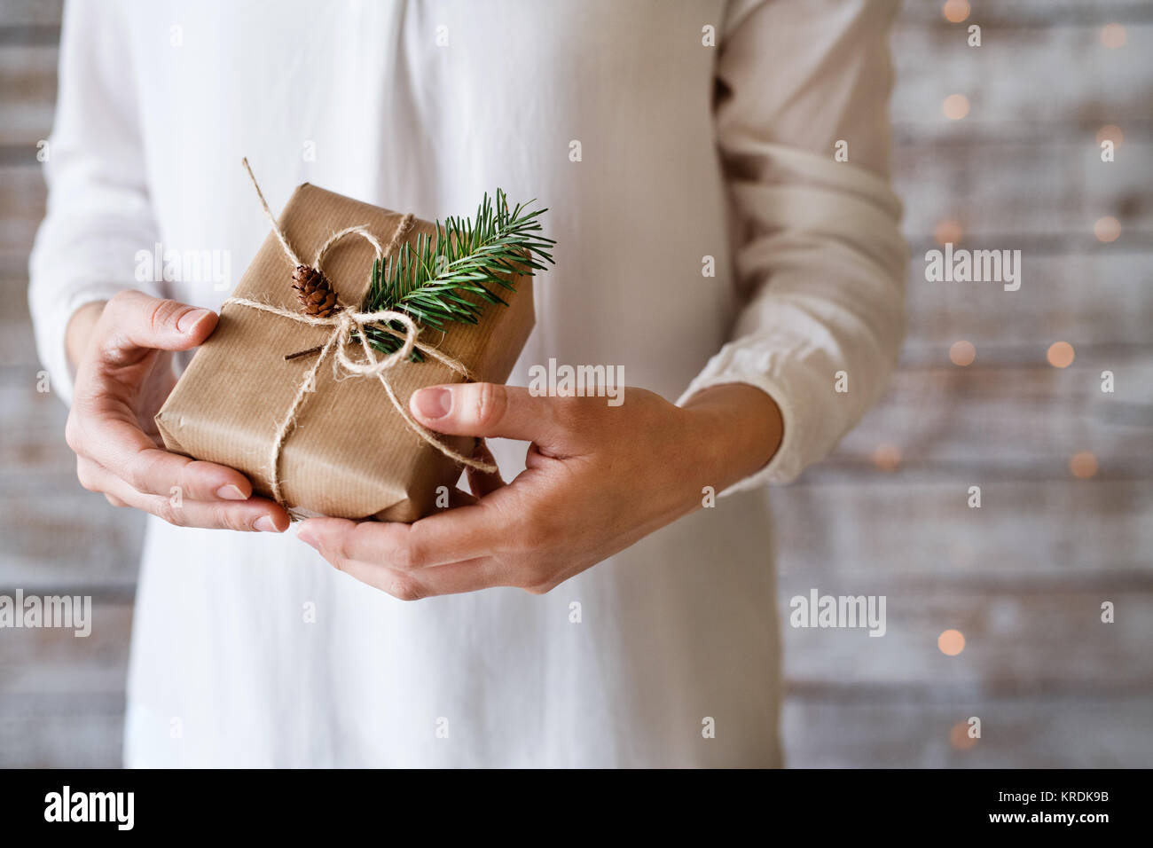 Young woman holding wrapped Christmas present Stock Photo - Alamy