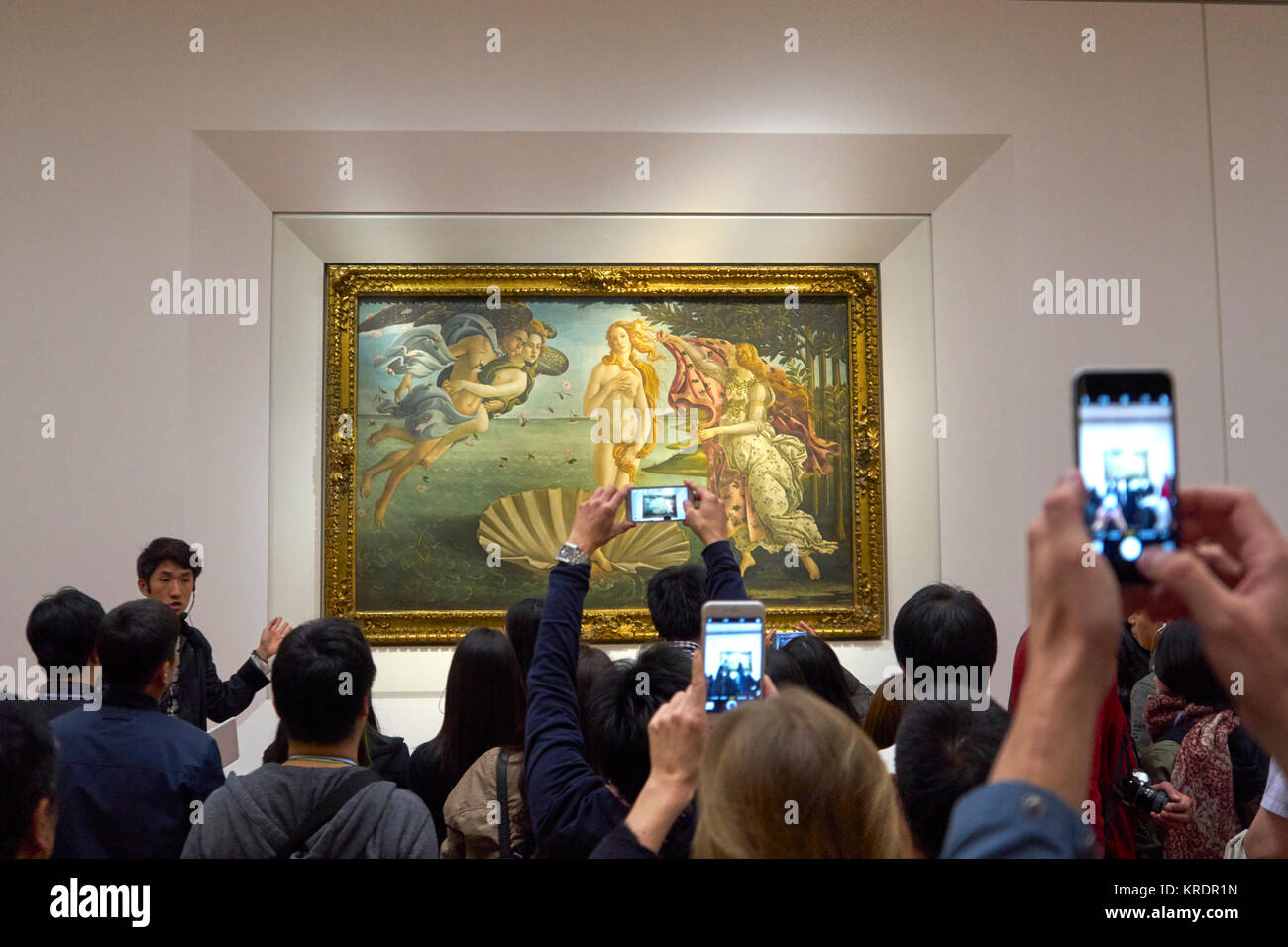 Florence, Italy, Uffizi Gallery, Botticelli's The Birth of Venus painting, with guide and tourists taking photos on smart phones Stock Photo