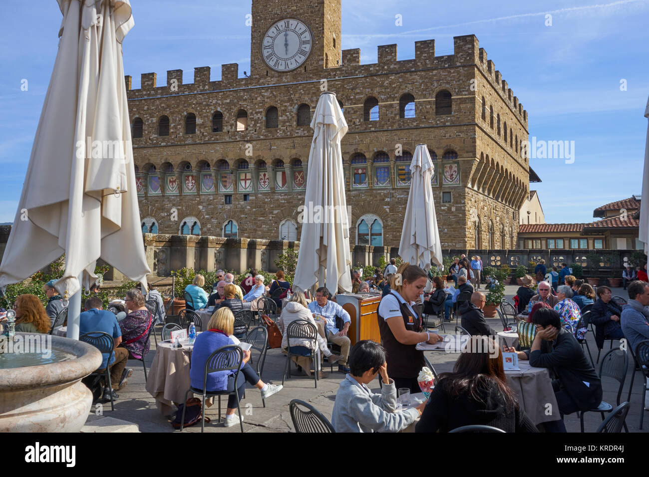 Florence, Italy, Uffizi Gallery, roof terrace cafe, with a waitress and visitors, and Palazzo Vecchio in background Stock Photo