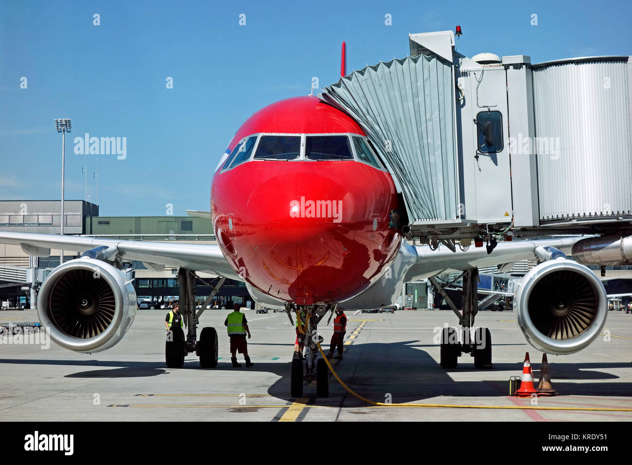 A jet aircraft being refuelled on the runway at a moderm airport with gangway or airbridge or tunnel attached. Taken at Zurich airport in Switzerland. Stock Photo