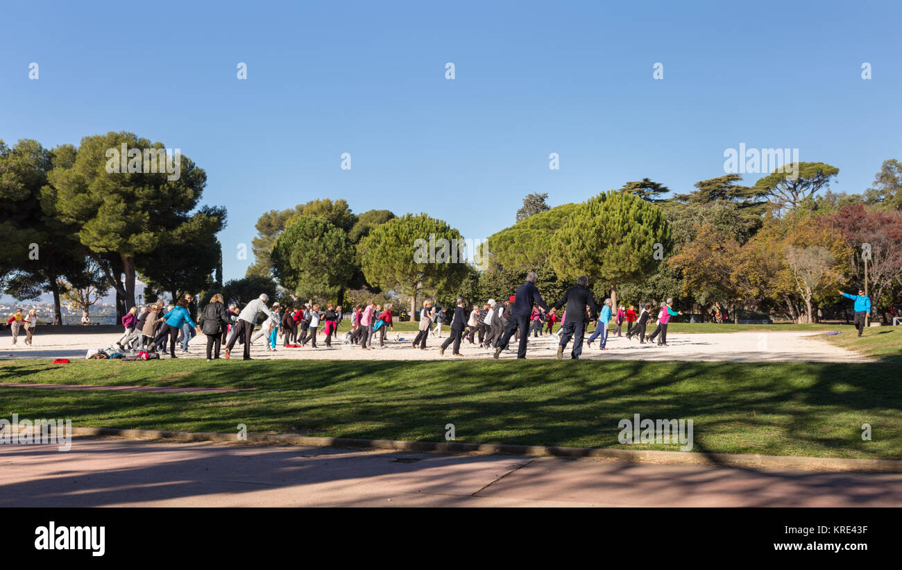 A large group of people doing fitness in the park with a trainer on Castle Hill, Nice, Cote d'Azur, France Stock Photo