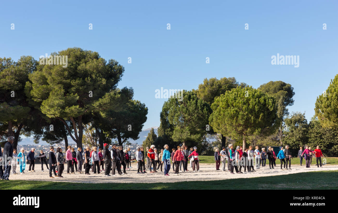 A large group of people doing fitness in the park with a trainer on Castle Hill, Nice, Cote d'Azur, France Stock Photo