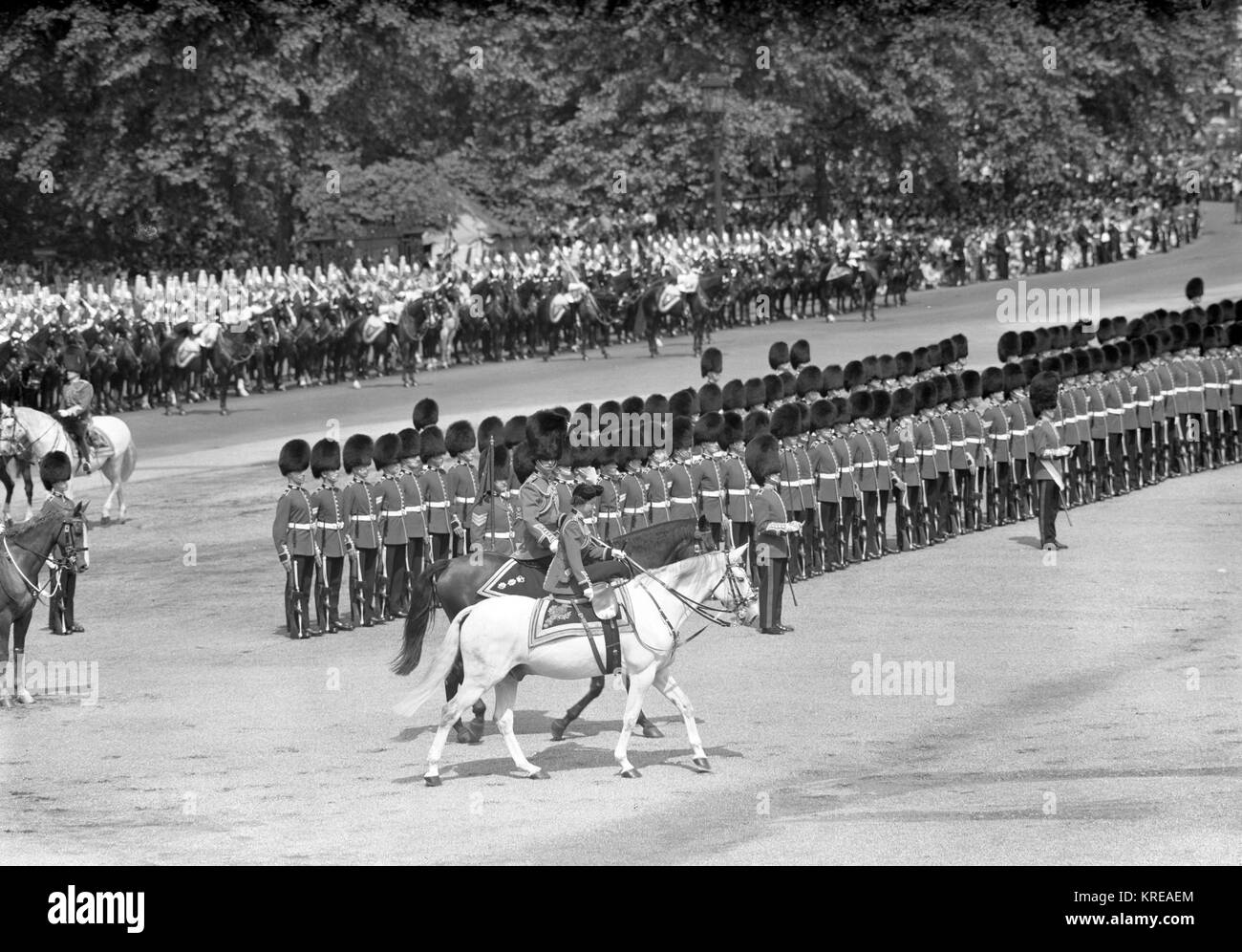 Queen Elizabeth II, mounted on a grey police horse named Doctor, is escorted by her husband, Prince Philip, Duke of Edinburgh, when she rides past the Guards at the Trooping the Colour ceremony on Horse Guards Parade, London. Stock Photo