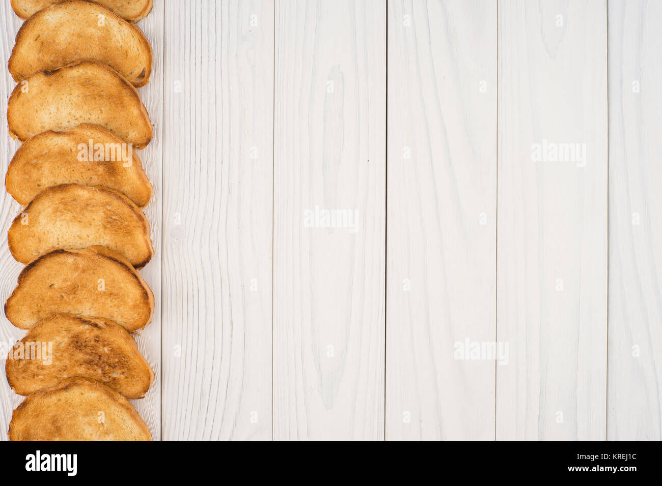 Toasted bread on an old white wooden table Stock Photo - Alamy