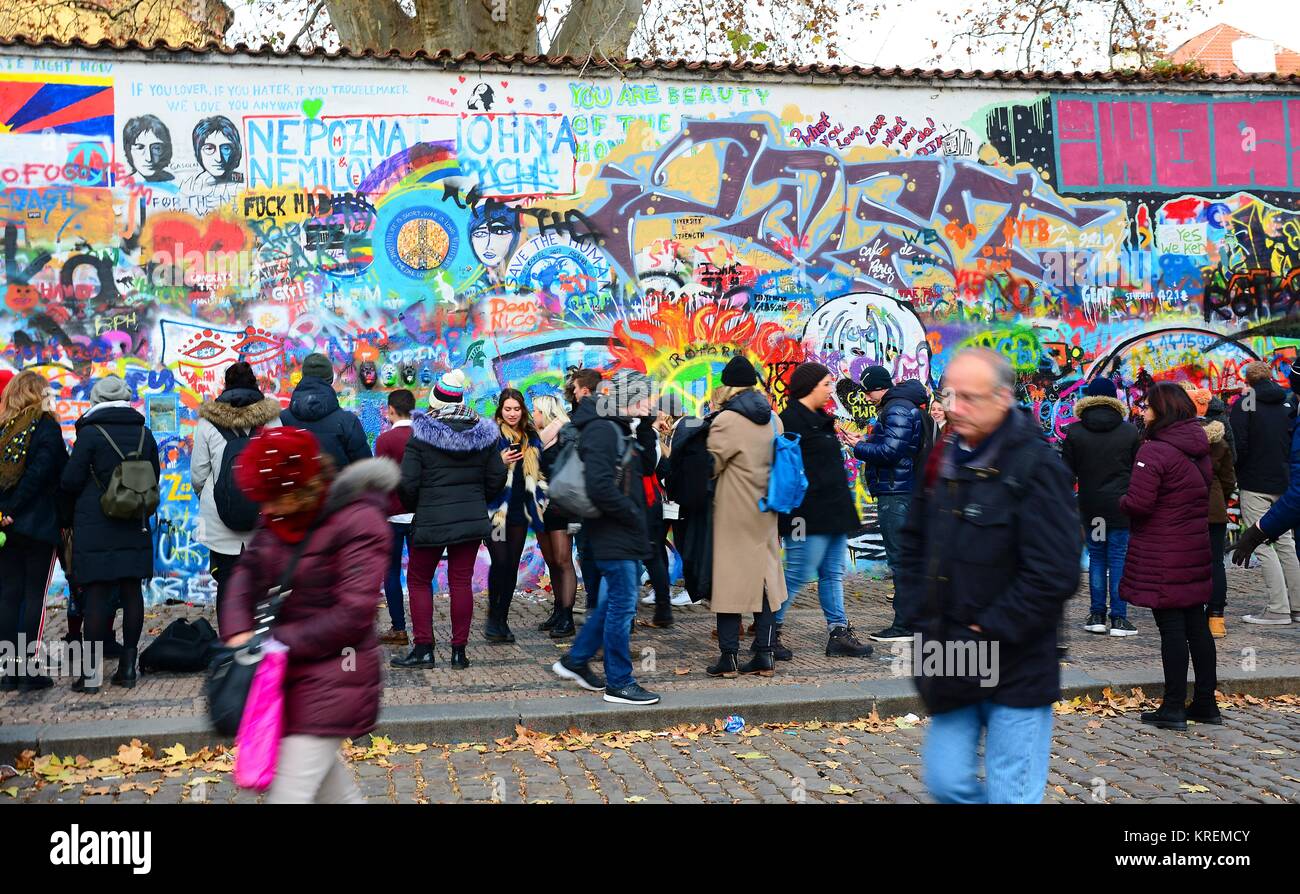 PRAGUE, CZECH REPUBLIC - DECEMBER 09, 2017: The tourist looking at memorial John Lennon Wall with graffiti paintings and pieces of lyrics from Beatles Stock Photo