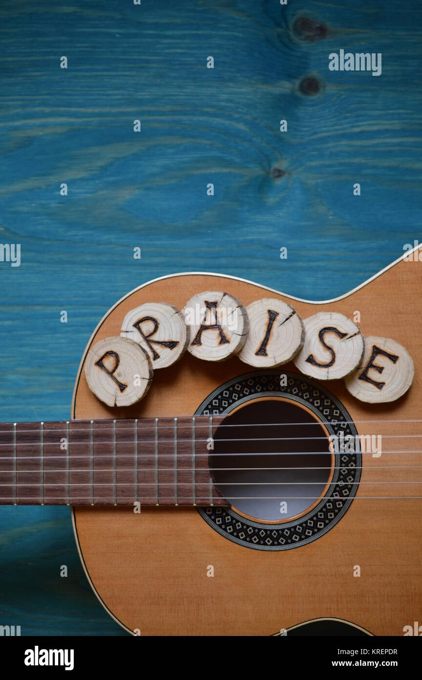 guitar on blue green wood with word: praise Stock Photo