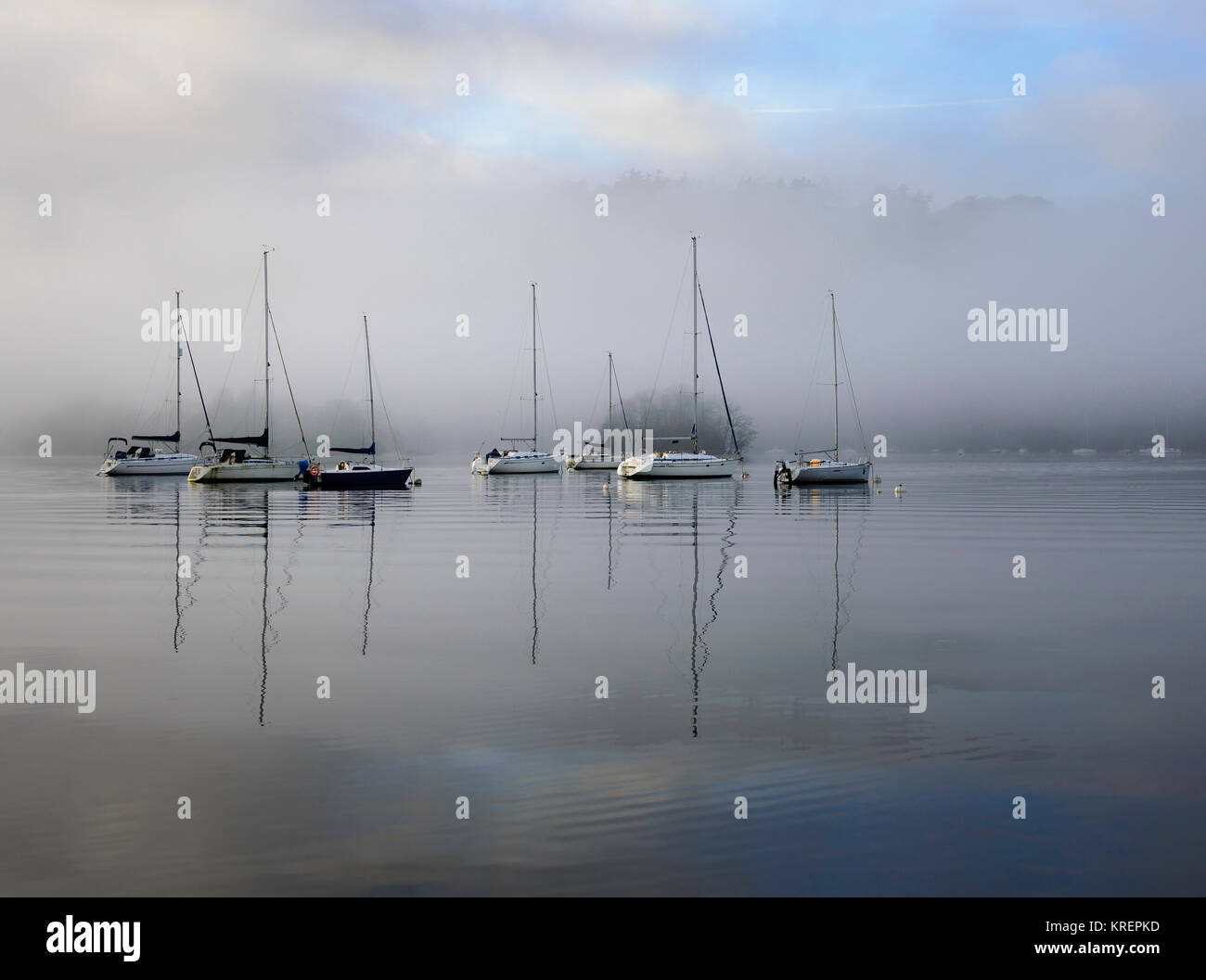 Boats on Windermere as the early morning mist starts to lift Stock