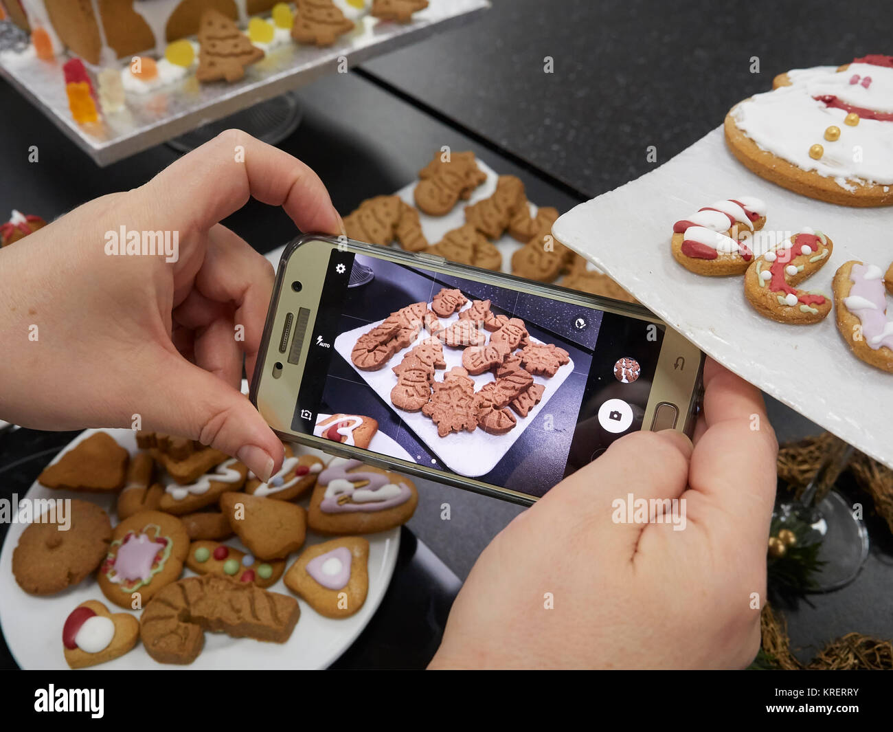 Woman taking a picture of digestive biscuits and gingerbread with a ...