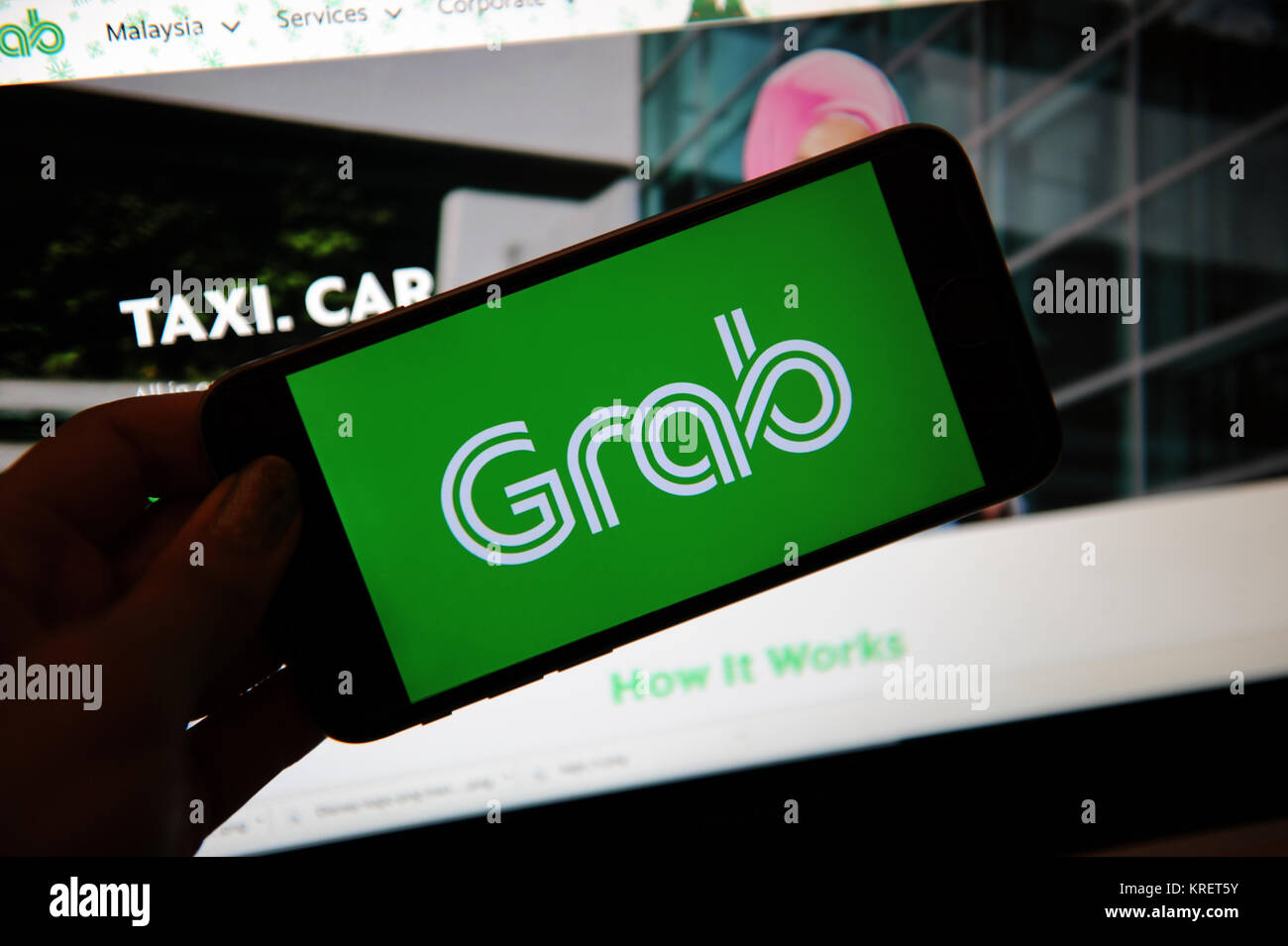 Grab, the ride hailing company logo on a phone and website on a computer screen Stock Photo Alamy