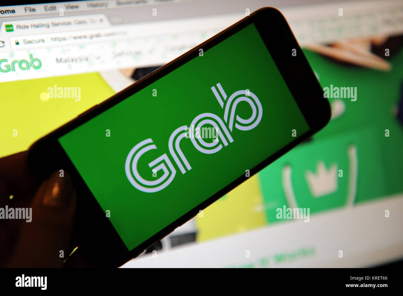 Grab, the ride hailing company logo on a phone and website on a