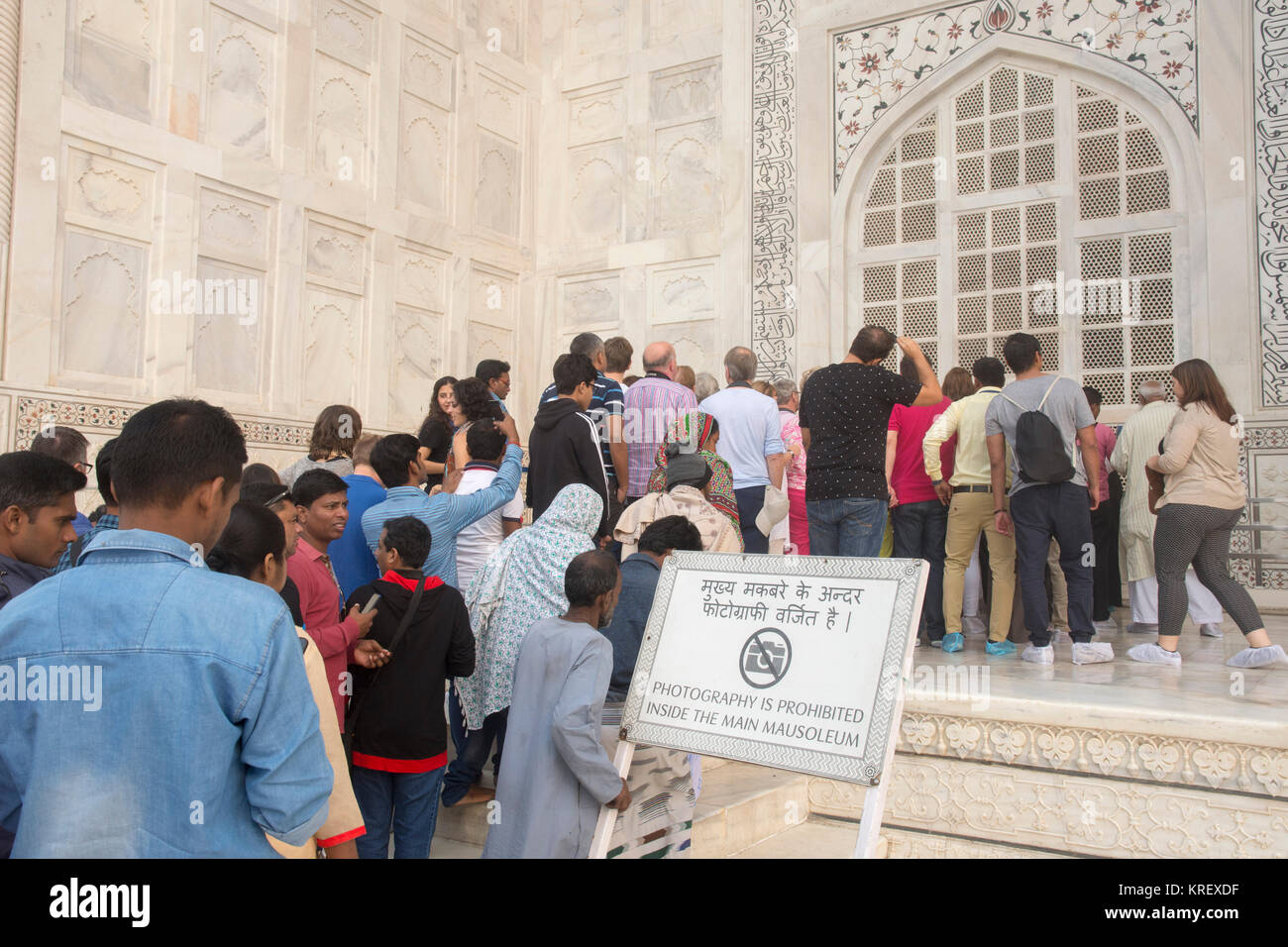 Signs reads 'Photography is prohibited inside the main mausoleum'  Large crowds, from all around the world, visit the Taj Mahal every day it is open. Stock Photo