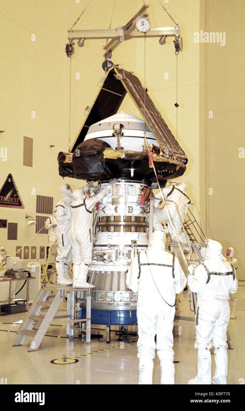 07/16/2001) --- KENNEDY SPACE CENTER, Fla. -- In the Payload Hazardous Servicing Facility, workers check the mating of the Genesis spacecraft with the upper stage of the Delta rocket. Genesis is 7.5 feet (2.3 meters) long and 6.6 feet (2 meters) wide, with a wingspan of solar array 26 feet (7.9 meters) tip to tip. Genesis will be on a robotic NASA space mission to catch a wisp of the raw material of the Sun and return it to Earth with a spectacular mid-air helicopter capture. The sample return capsule is 4.9 feet in diameter. Genesis mounted on Delta motor KSC-01pp1299 Stock Photo