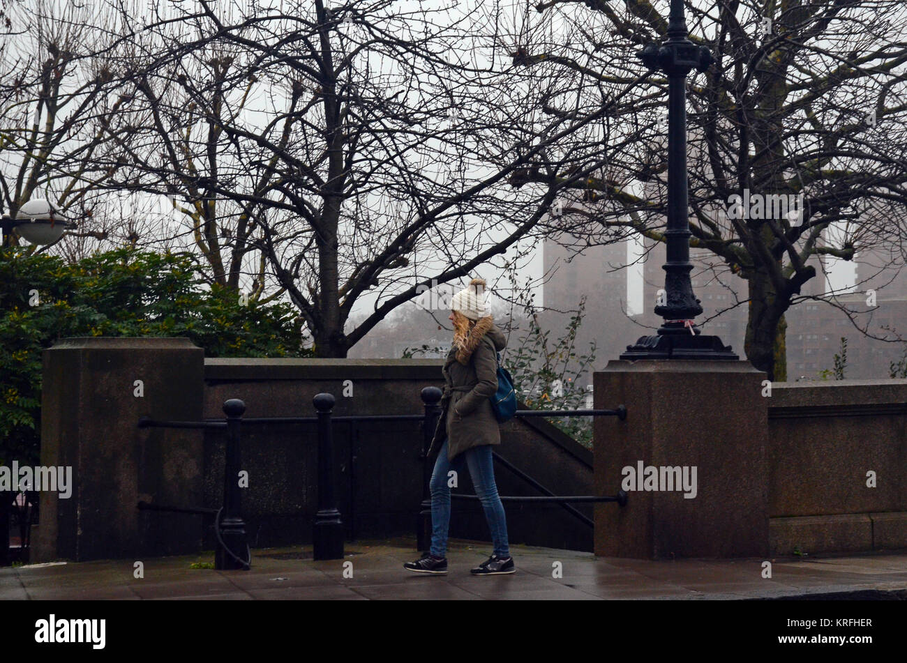 London, UK, 20/12/2017 People walking over Battersea Bridge. Heavy fog