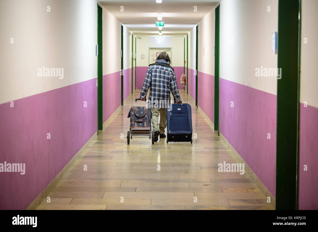 Munich, Germany. 14th Dec, 2017. A homeless person pulls two suitcases  along a hallway at the night shelter for homeless people on the grounds of  the Bayernkaserne ('Bavaria barracks') in Munich, Germany,