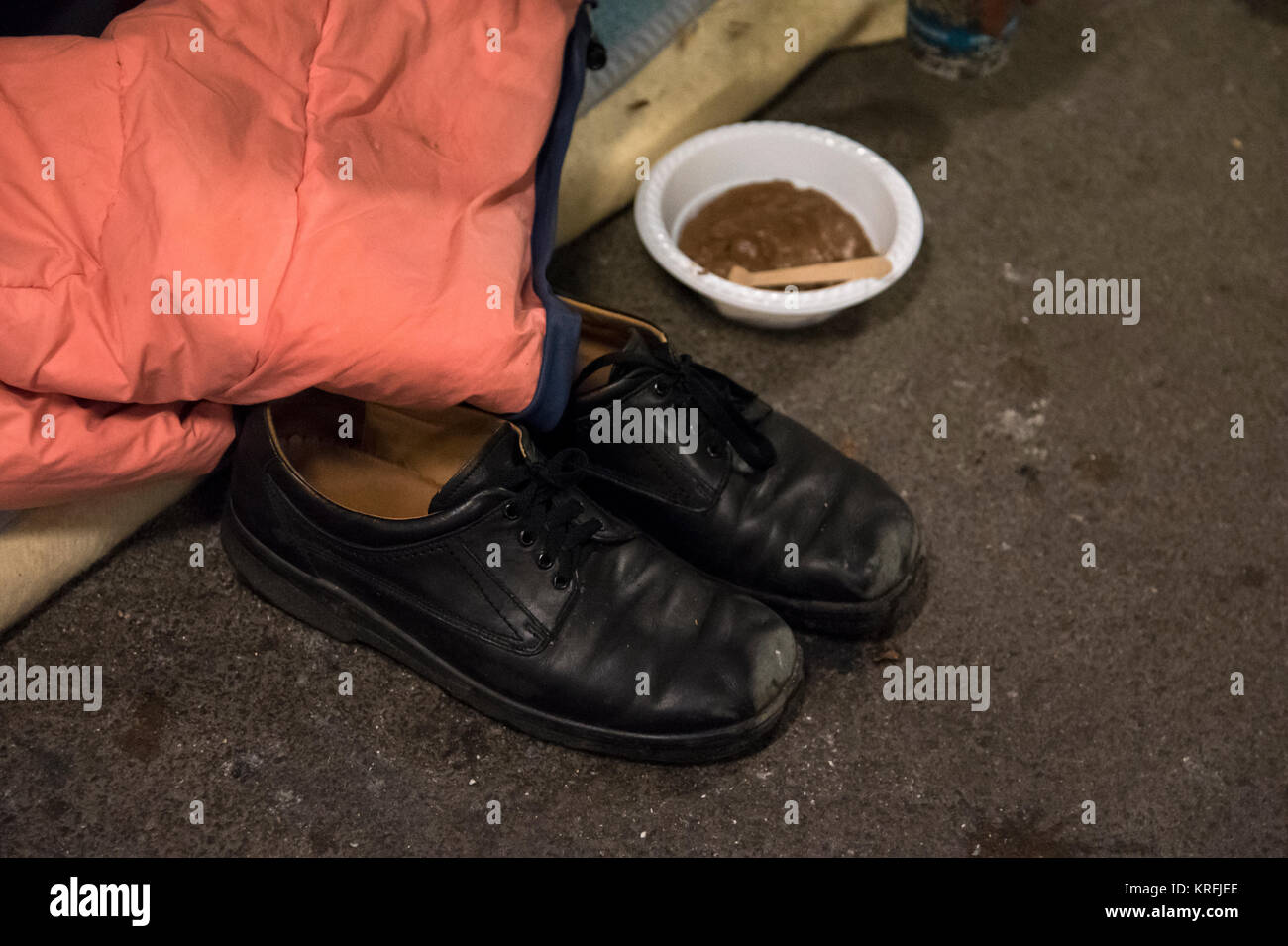 Munich, Germany. 16th Nov, 2017. A pair of shoes and a plate with food handed out by the organisation 'Kaeltebus e.V.' (lit. 'Cold Bus') can be seen on the ground in Munich, Germany, 16 November 2017. The voluntary workers of the winter bus bring out warm food and drinks to homeless people Credit: Amelie Geiger/dpa/Alamy Live News Stock Photo