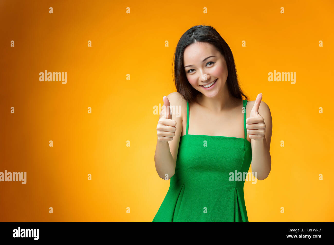 The happy Chinese girl on yellow background Stock Photo