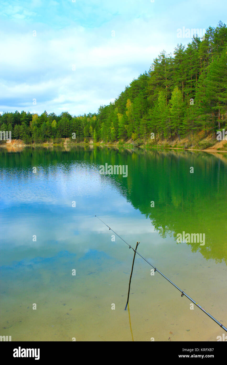 lake in the forest and fishingrod Stock Photo Alamy