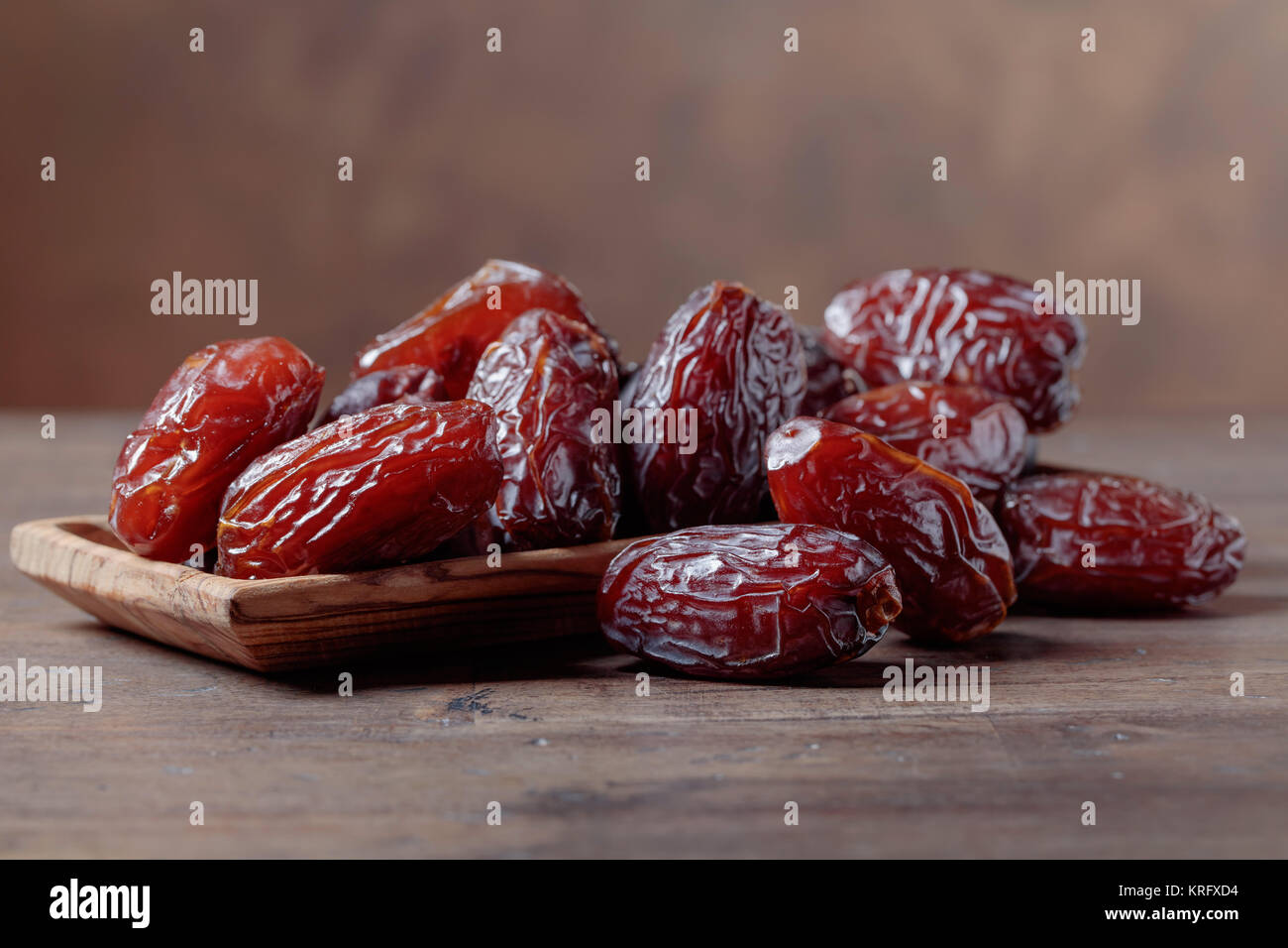 Juicy dates in a bowl on a old wooden table Stock Photo - Alamy