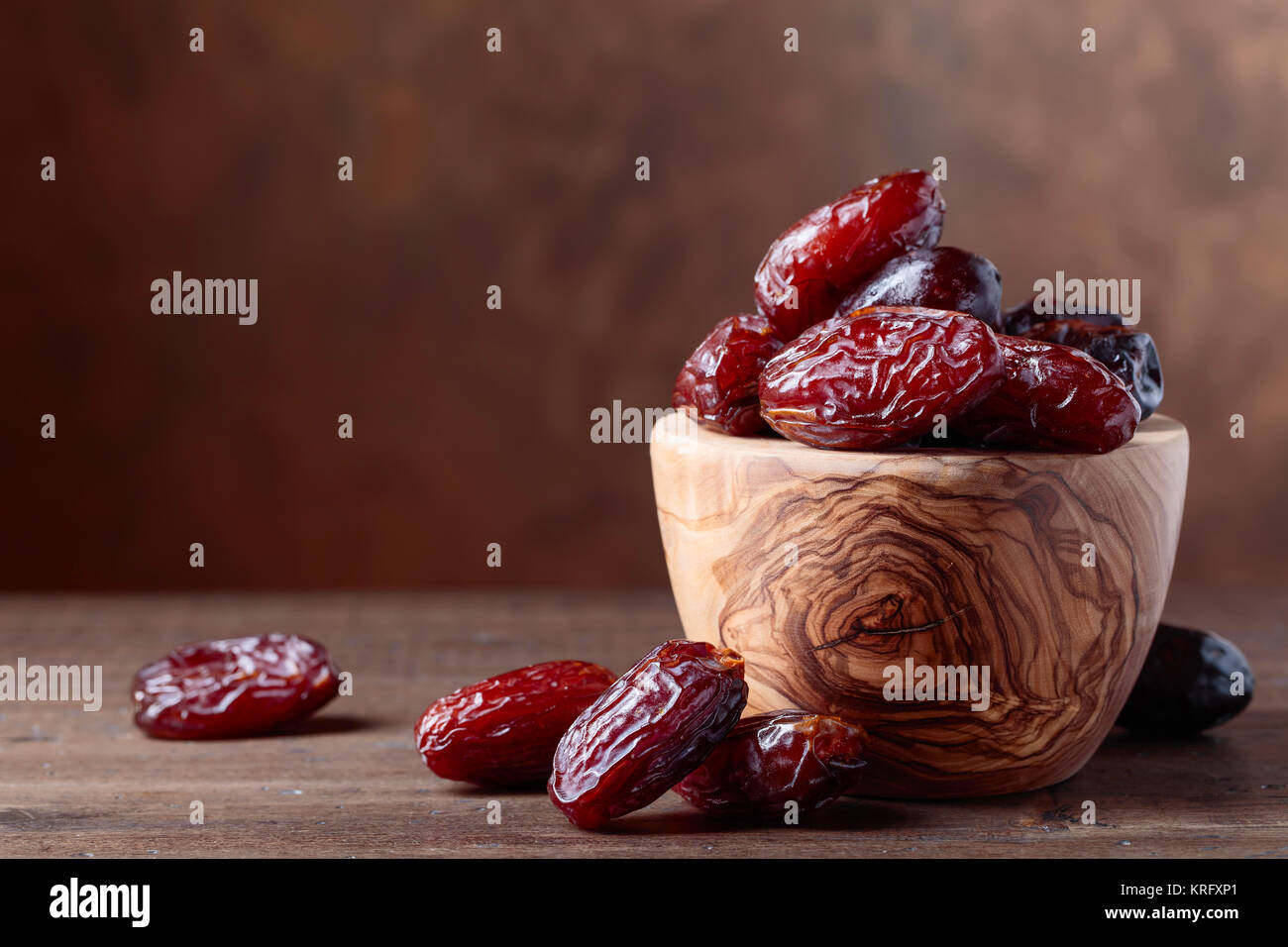 Juicy dates in a bowl on a old wooden table . Copy space Stock Photo ...
