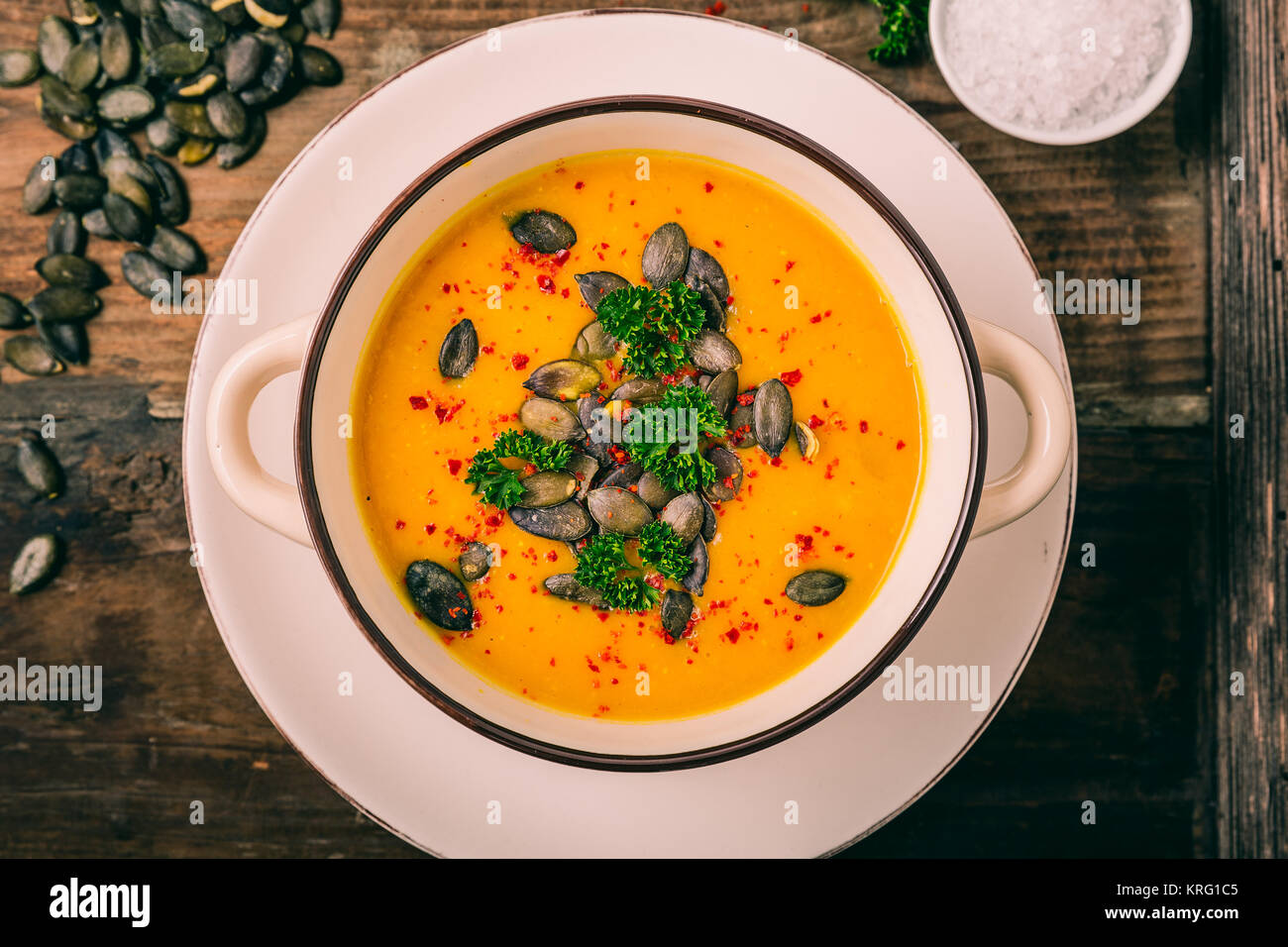 Kürbis Suppe mit Kürbiskernen, Petersilie  und Chiliflocken Stock Photo