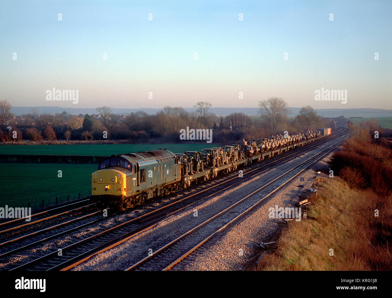 A class 37 with a train of military vehicles near Cholsey on
