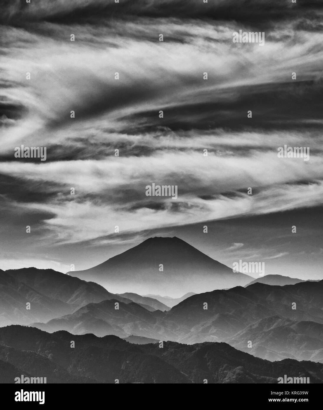Iconic Mount Fuji wrapped in misty clouds like and old painting, seen from Mount Takao in Japan (Black and White) Stock Photo