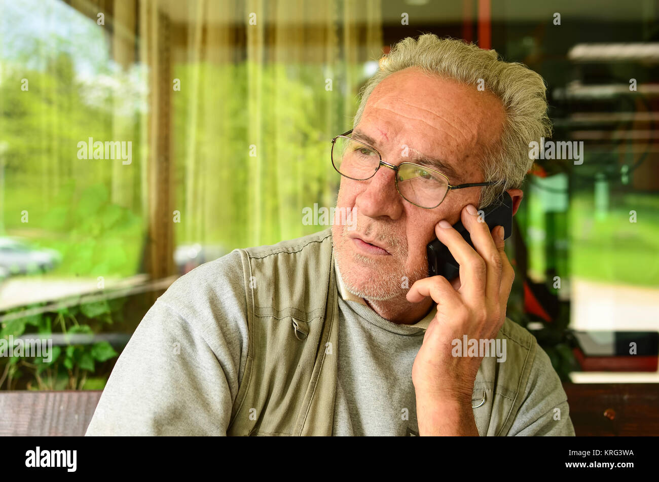 Just heard the bad news - old man using mobile phone Stock Photo