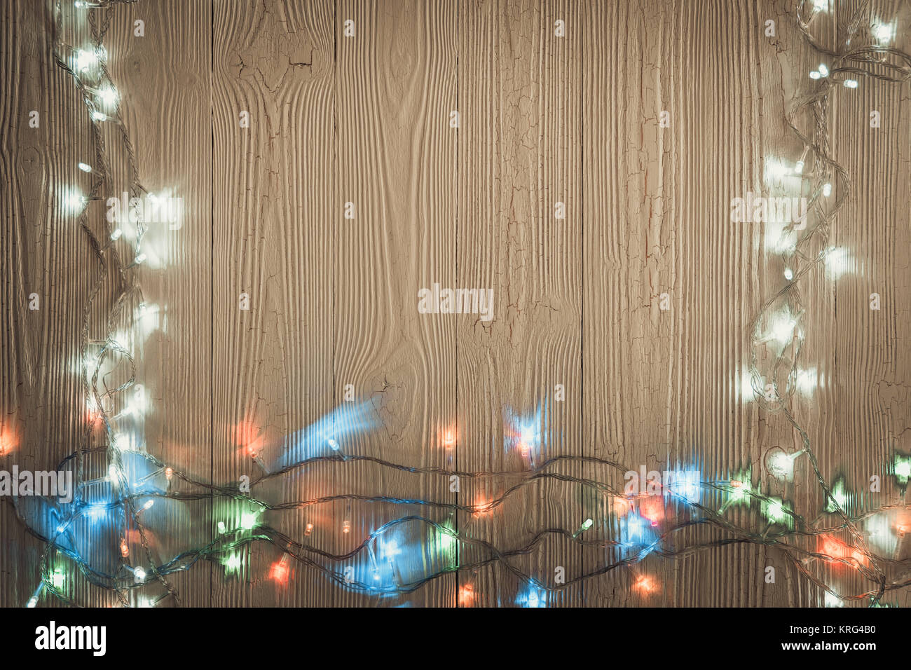 Fancy blinker light bulbs or garlands and wreath on wood table for