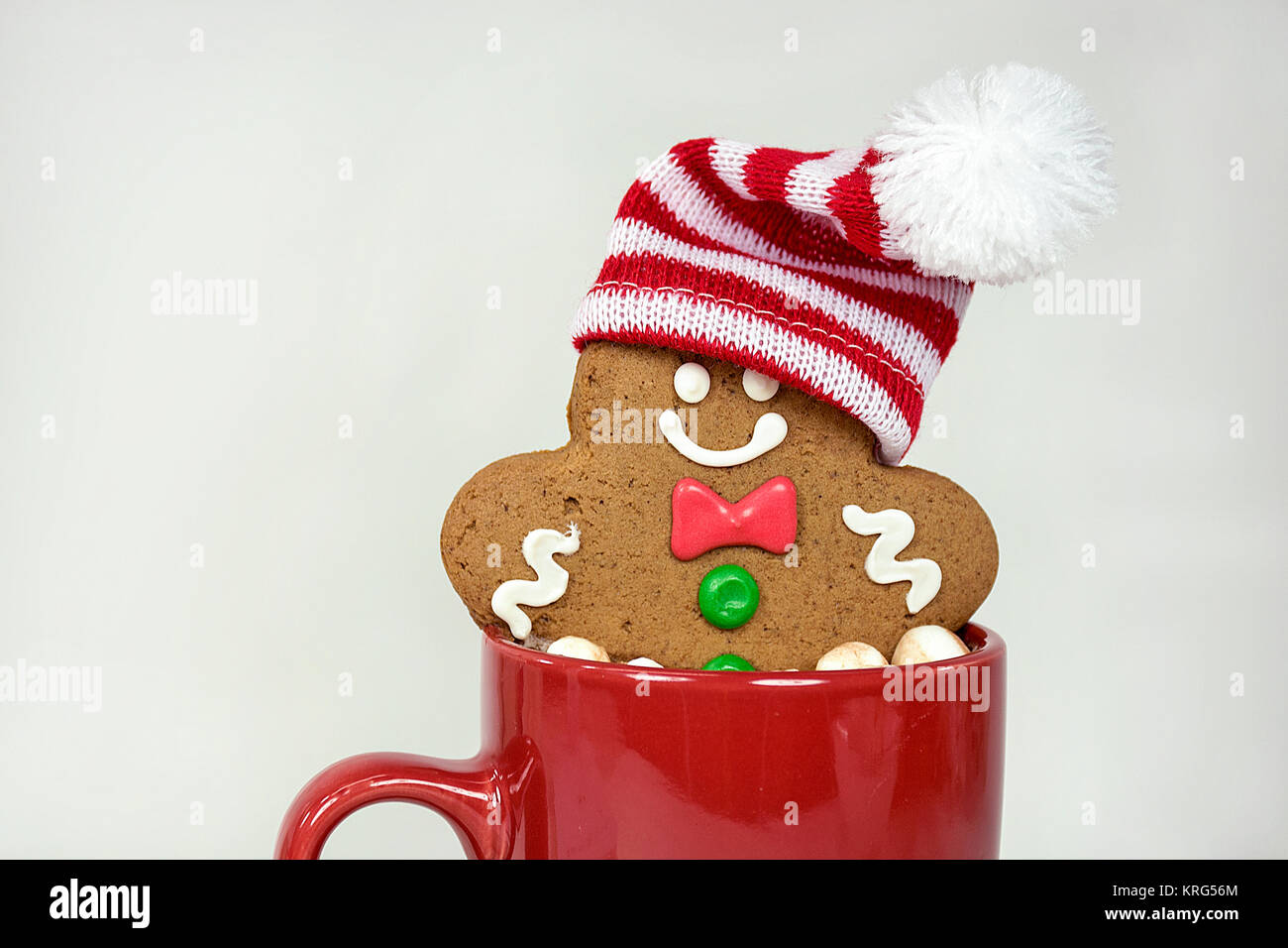 Christmas gingerbread man with stocking cap in hot chocolate drink in red mug isolated on white background Stock Photo