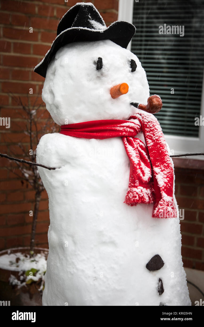 A snowman in the front garden of a London suburban house. Stock Photo