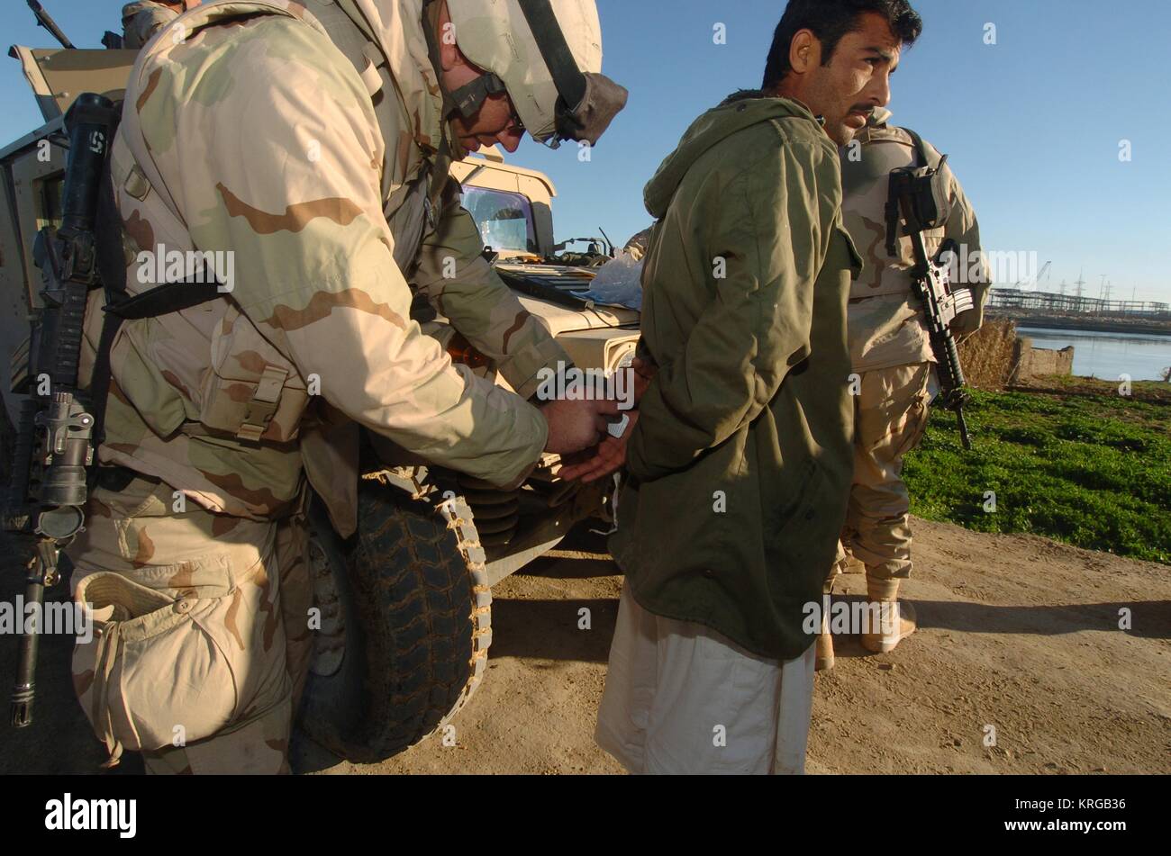 U.S. soldiers and Iraqi National Guard officers swab suspected insurgents hands for explosive residue during a raid near Forward Operating Base Dogwood March 25, 2005 in Babil Province, Iraq. Stock Photo
