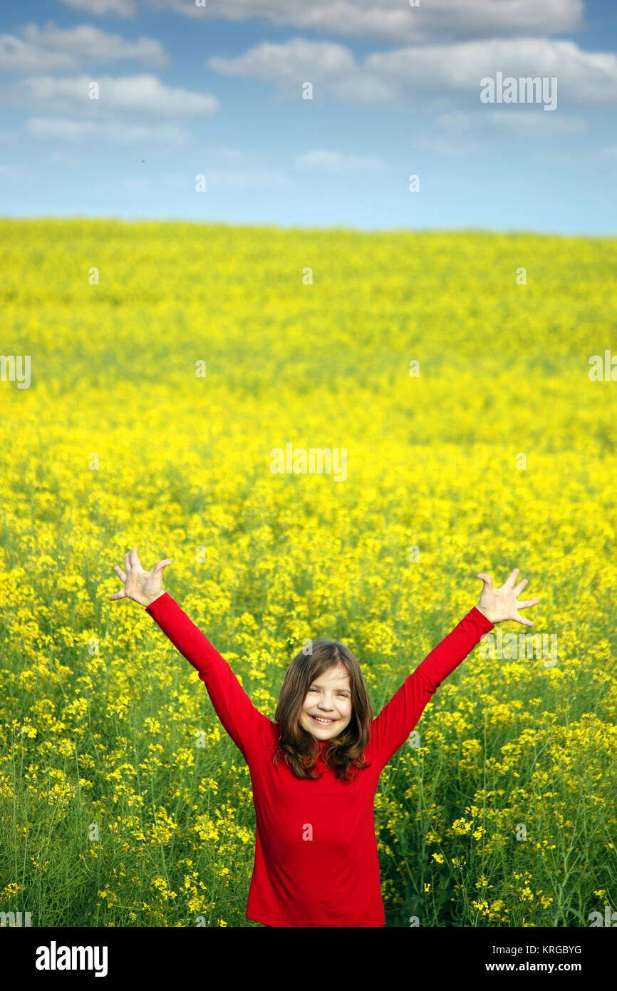 little girl with hands up on yellow field spring season Stock Photo - Alamy