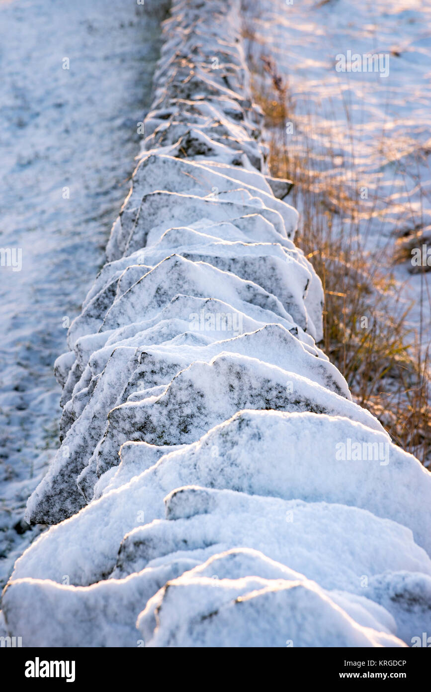 The top of a drystone wall covered in snow Stock Photo