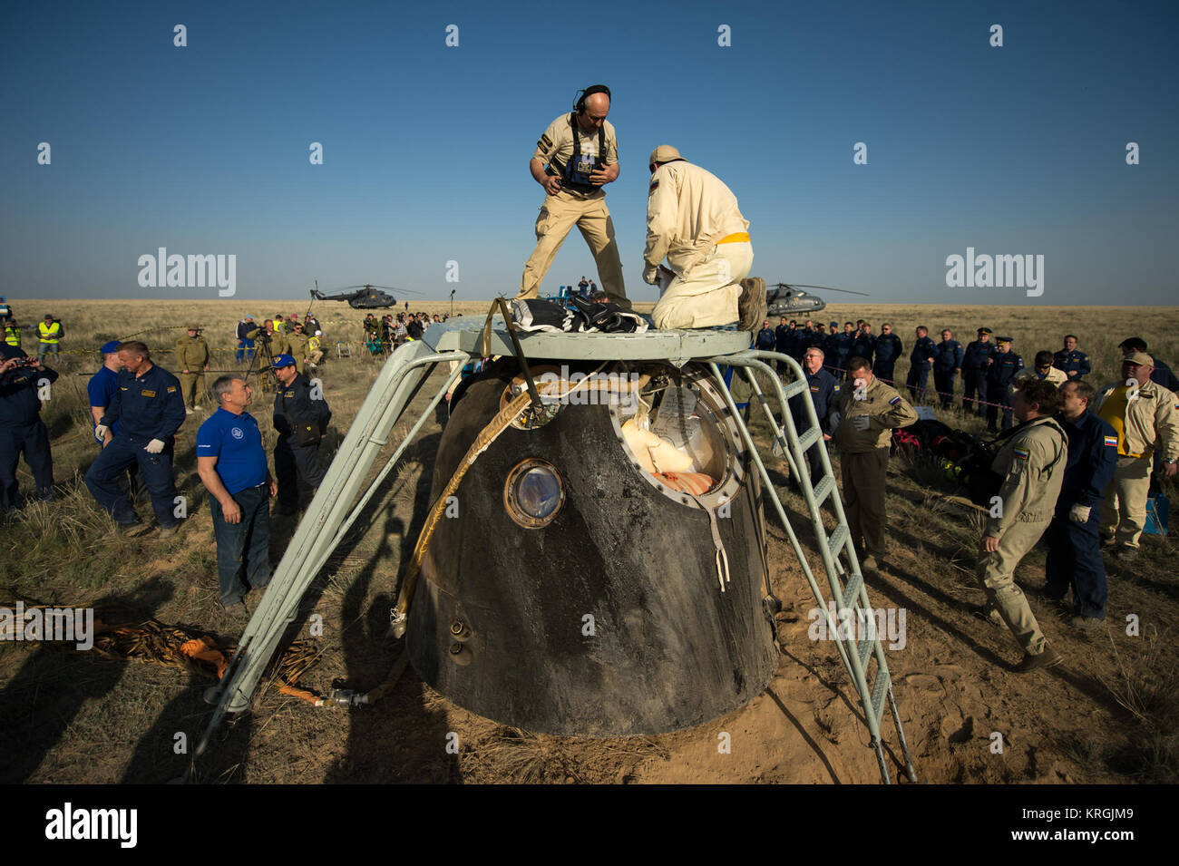 Support personnel prepare to exact the crew from the Soyuz TMA-11M spacecraft shortly after it landed with Expedition 39 Commander Koichi Wakata of the Japan Aerospace Exploration Agency (JAXA), Soyuz Commander Mikhail Tyurin of Roscosmos, and Flight Engineer Rick Mastracchio of NASA near the town of Zhezkazgan, Kazakhstan on Wednesday, May 14, 2014. Wakata, Tyurin and Mastracchio returned to Earth after more than six months onboard the International Space Station where they served as members of the Expedition 38 and 39 crews. Photo Credit: (NASA/Bill Ingalls) Soyuz TMA-11M capsule shortly aft Stock Photo