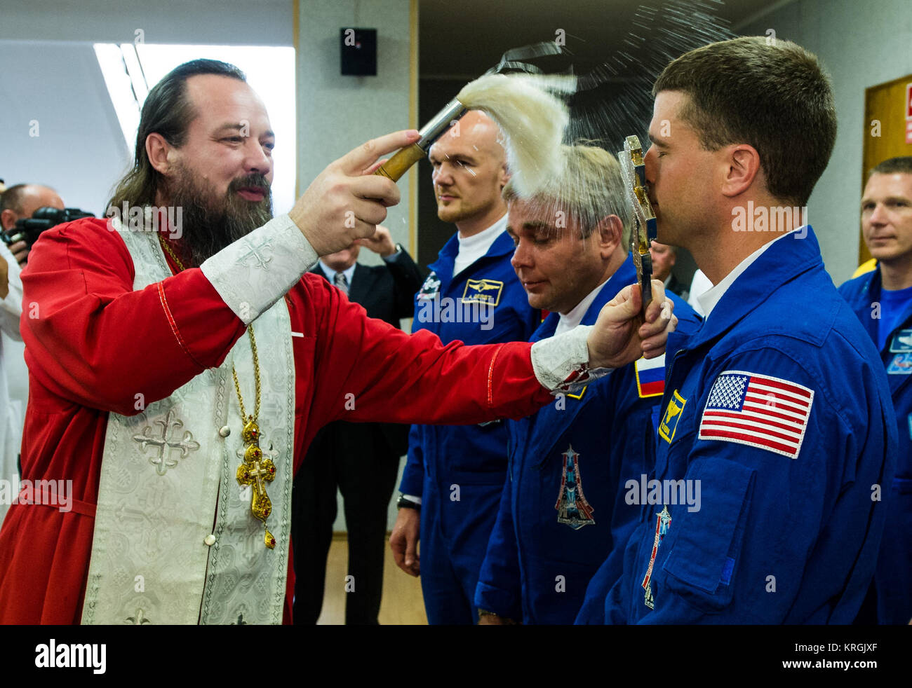 Expedition 40 Flight Engineer Reid Wiseman of NASA, right, receives the traditional blessing from a Russian Orthodox priest at the Cosmonaut Hotel prior to his launch on the Soyuz rocket to the International Space Station, Wednesday, May 28, 2014, in Baikonur, Kazakhstan. Wiseman, Soyuz Commander Maxim Suraev of the Russian Federal Space Agency, Roscosmos, center, and Flight Engineer Alexander Gerst of the European Space Agency, ESA, left, will spend the next five and a half months living and working aboard the ISS. Photo Credit: (NASA/Joel Kowsky) Expedition 40 Preflight (201405280008HQ) Stock Photo