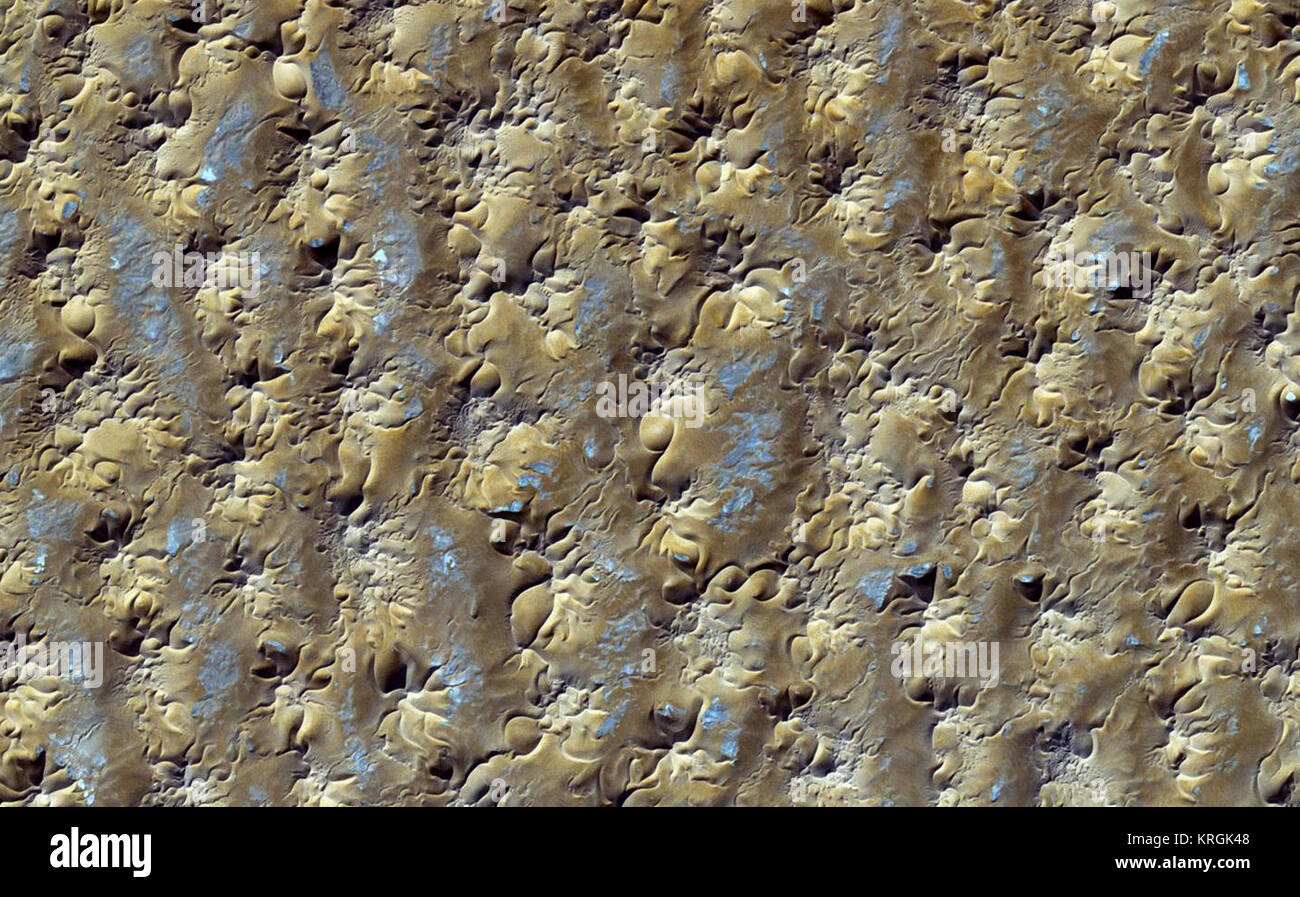 Star Dunes in Algeria  The image was acquired by the Advanced Spaceborne Thermal Emission and Reflection Radiometer (ASTER) on NASA’s Terra satellite on October 27, 2012. It was made from a combination of near-infrared and visible light. In this type of false-color image, sand is tan and shadows are black or gray. The blue-tinted areas are likely mineral-rich evaporites. The image is centered at 29.8°north latitude, 7.9°east longitude, near the town of Gadamis. As is common with star dunes, some of the dunes have long interlacing arms connecting to nearby dunes.  NASA image courtesy NASA/GSFC/ Stock Photo