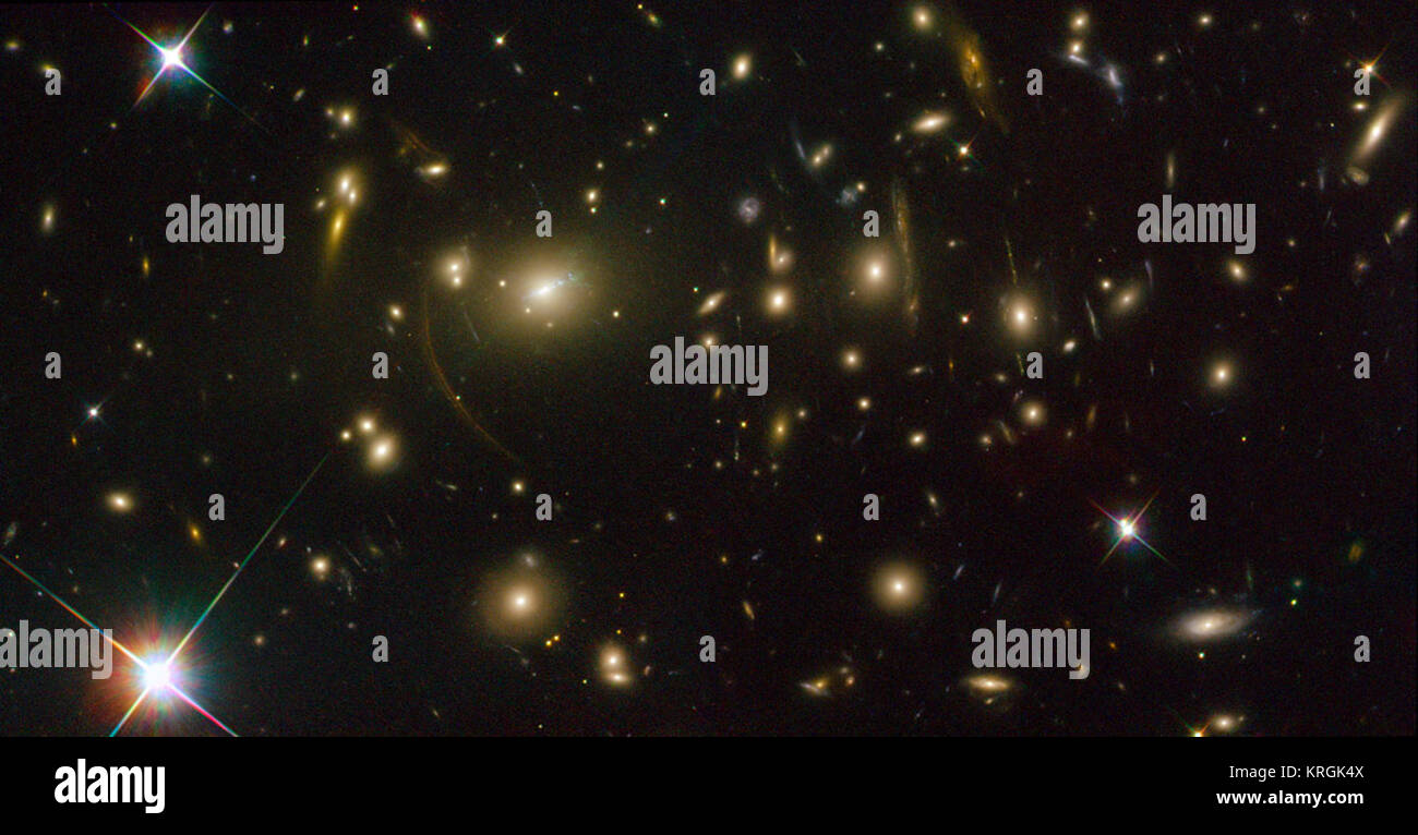 Located 2.7 billion light-years from the Earth (redshift 0.23), Abell 2390 is located in the constellation Pegasus. The large arcs seen around the central cluster are distortions of other objects located behind Abell 2390, the light from which is bent and magnified as it passes by the galaxy cluster. When a massive galaxy cluster acts as a lens, like in these new Hubble images, arcs and arclets of light are formed. The images come in different sizes and shapes depending on how distant they are from us and each other and how close the source light passes by the galaxy cluster itself. The extent Stock Photo