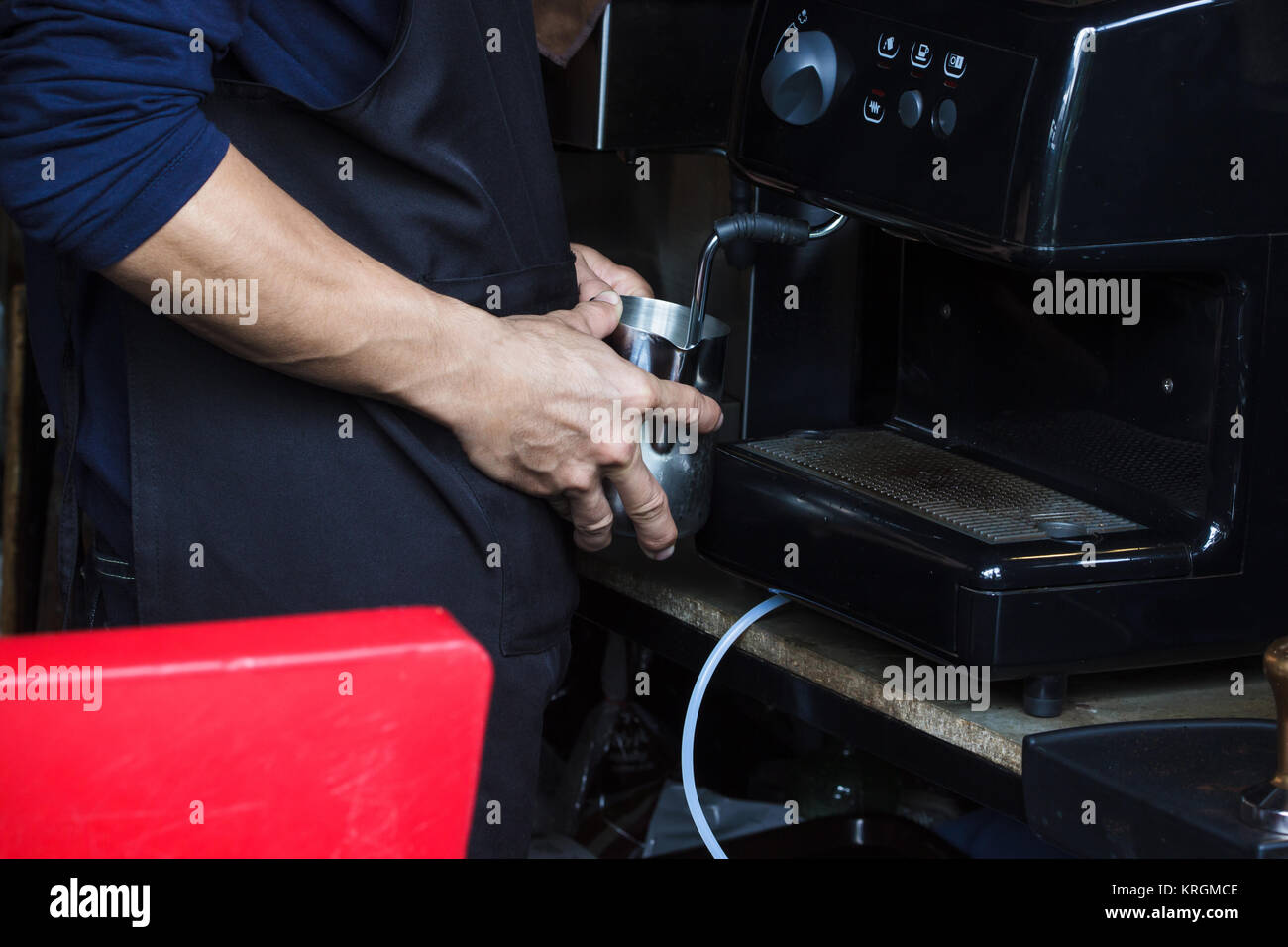 Barista using coffee machine to Steaming milk froth for preparing