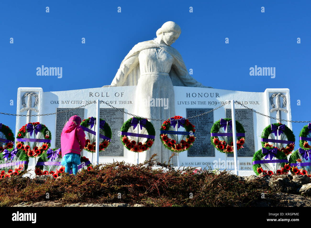 A small child looks at a war memorial on Remembrance day. Stock Photo